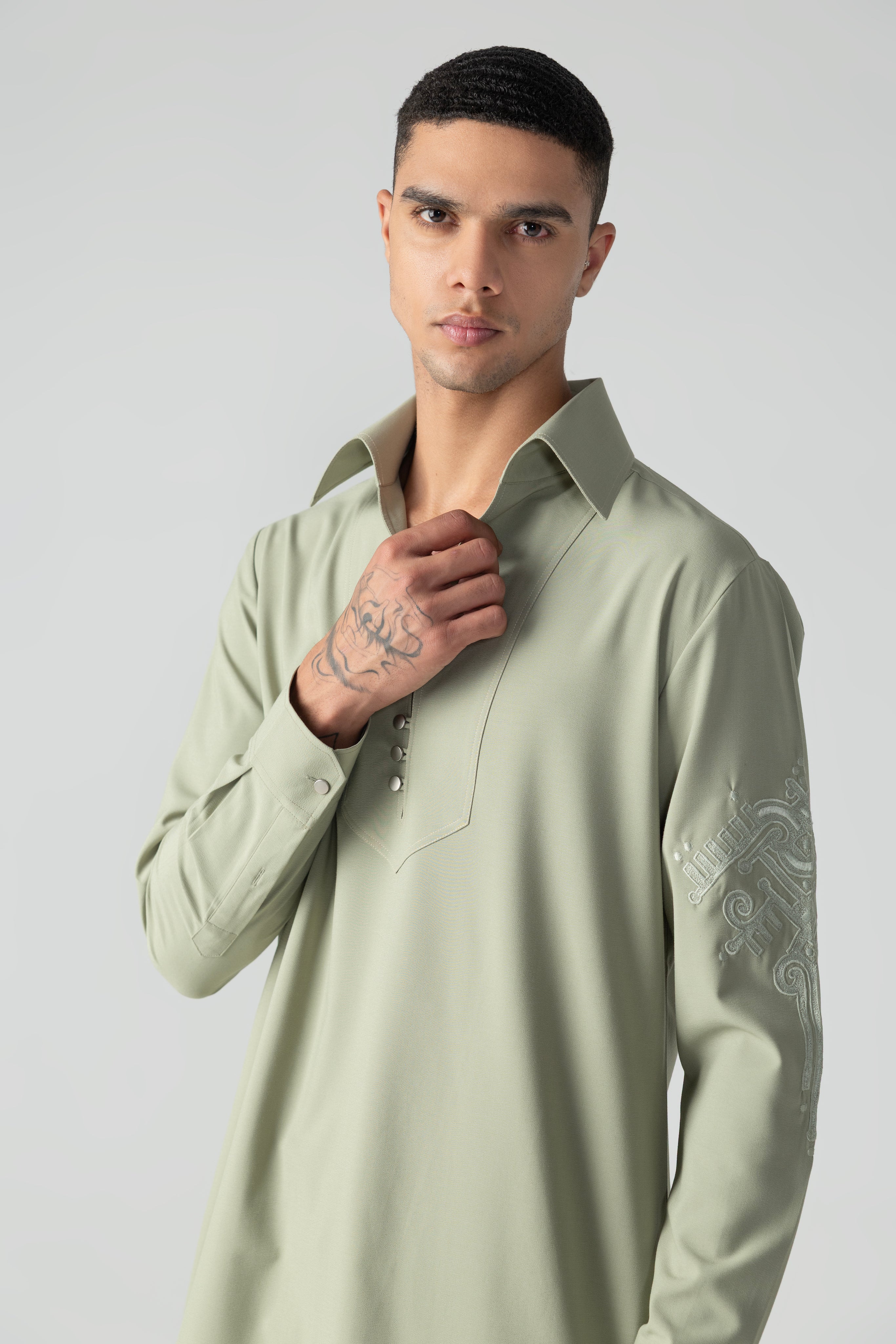 Mint green short crepe kurta with thread embroidery detailing on the sleeve, paired with a matching plazzo