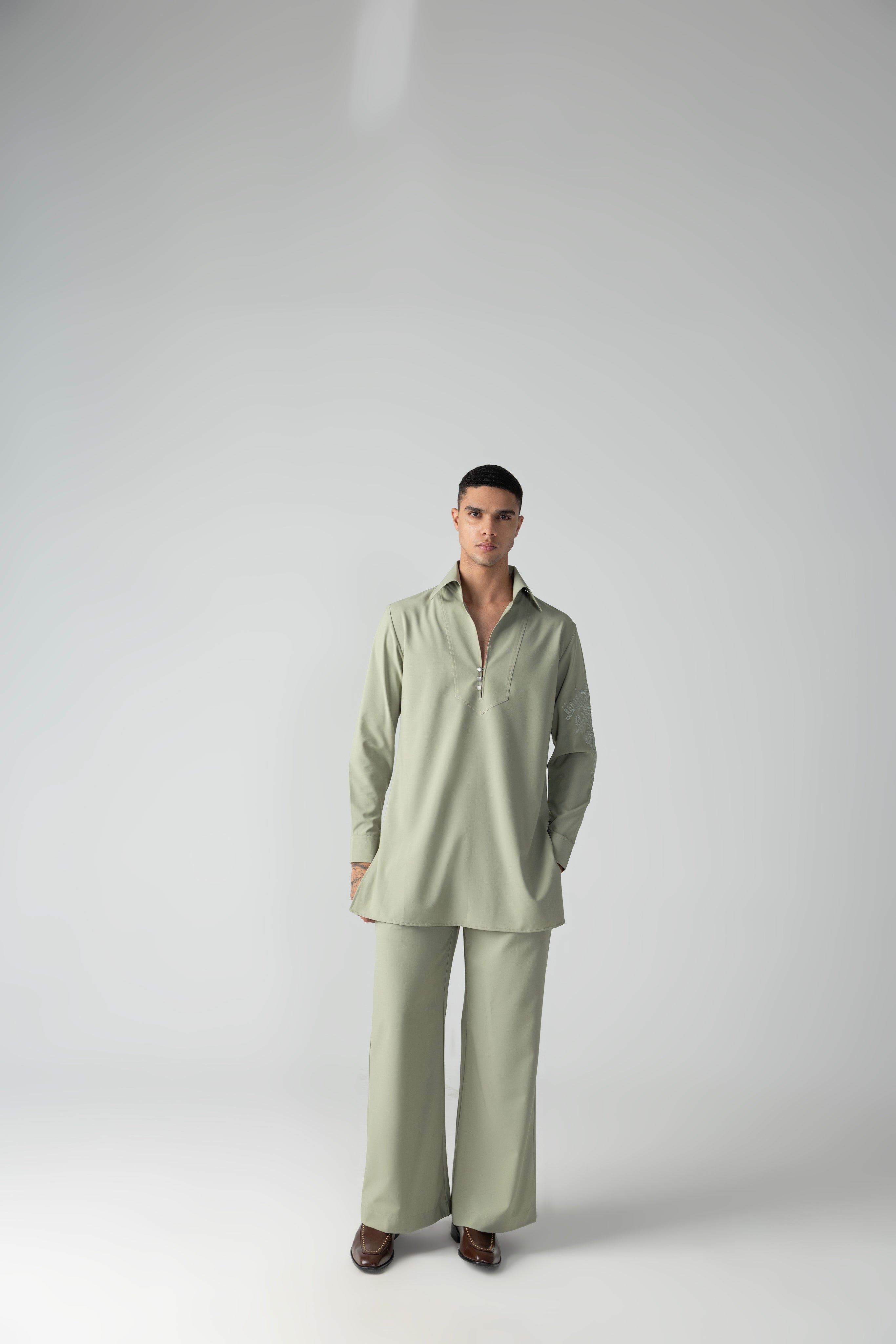 Mint green short crepe kurta with thread embroidery detailing on the sleeve, paired with a matching plazzo