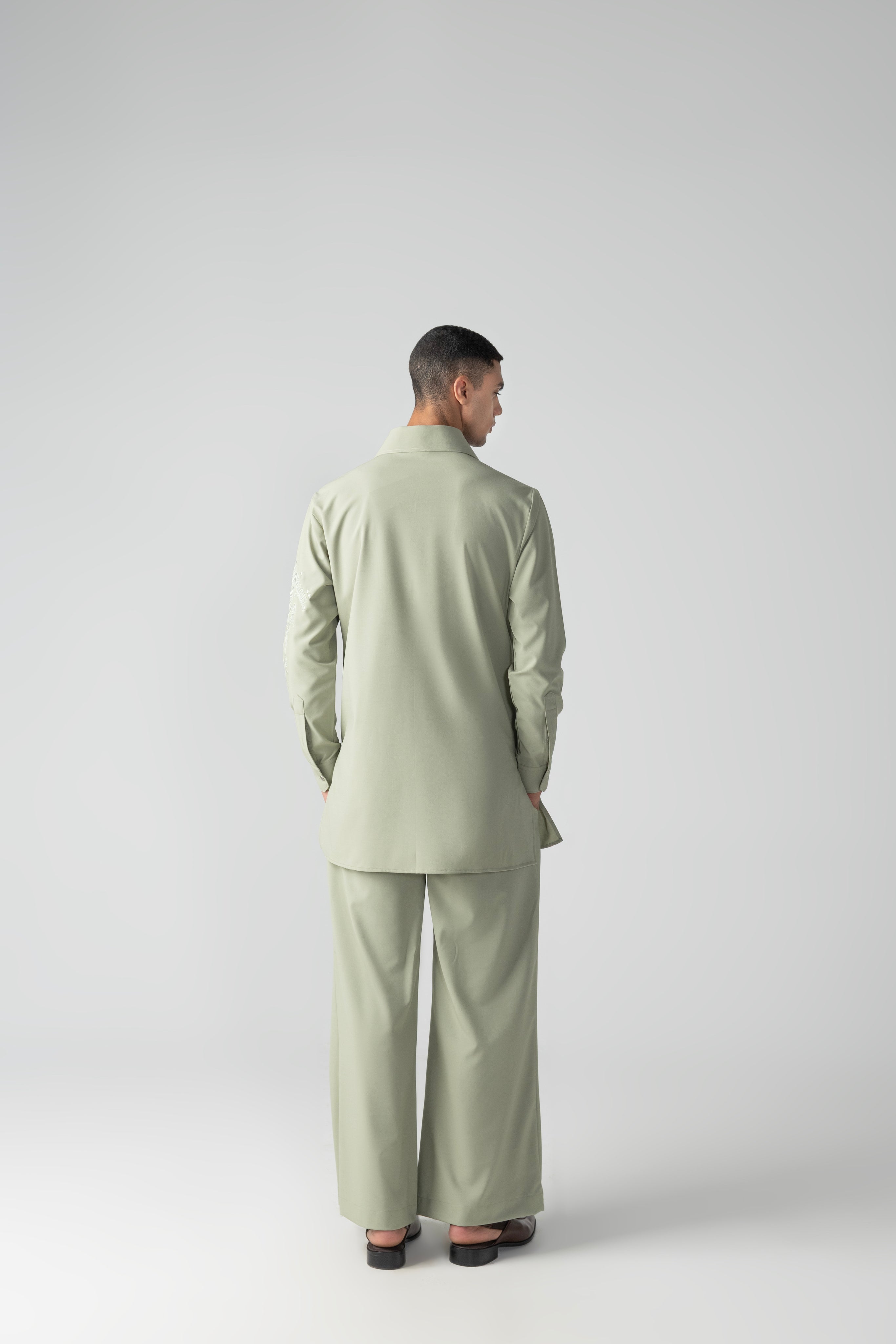 Mint green short crepe kurta with thread embroidery detailing on the sleeve, paired with a matching plazzo