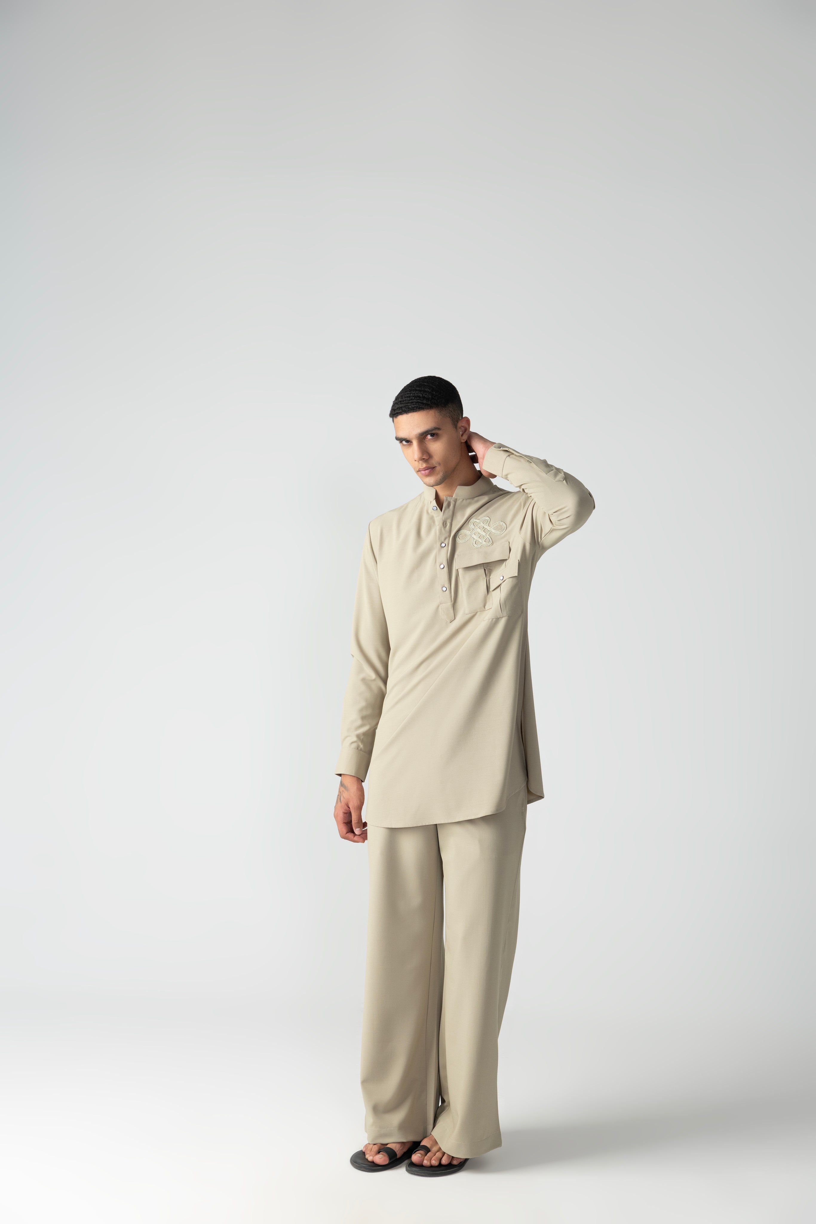 Beige short crepe kurta with patch pocket & thread embroidery detailing, paired with a matching plazzo.