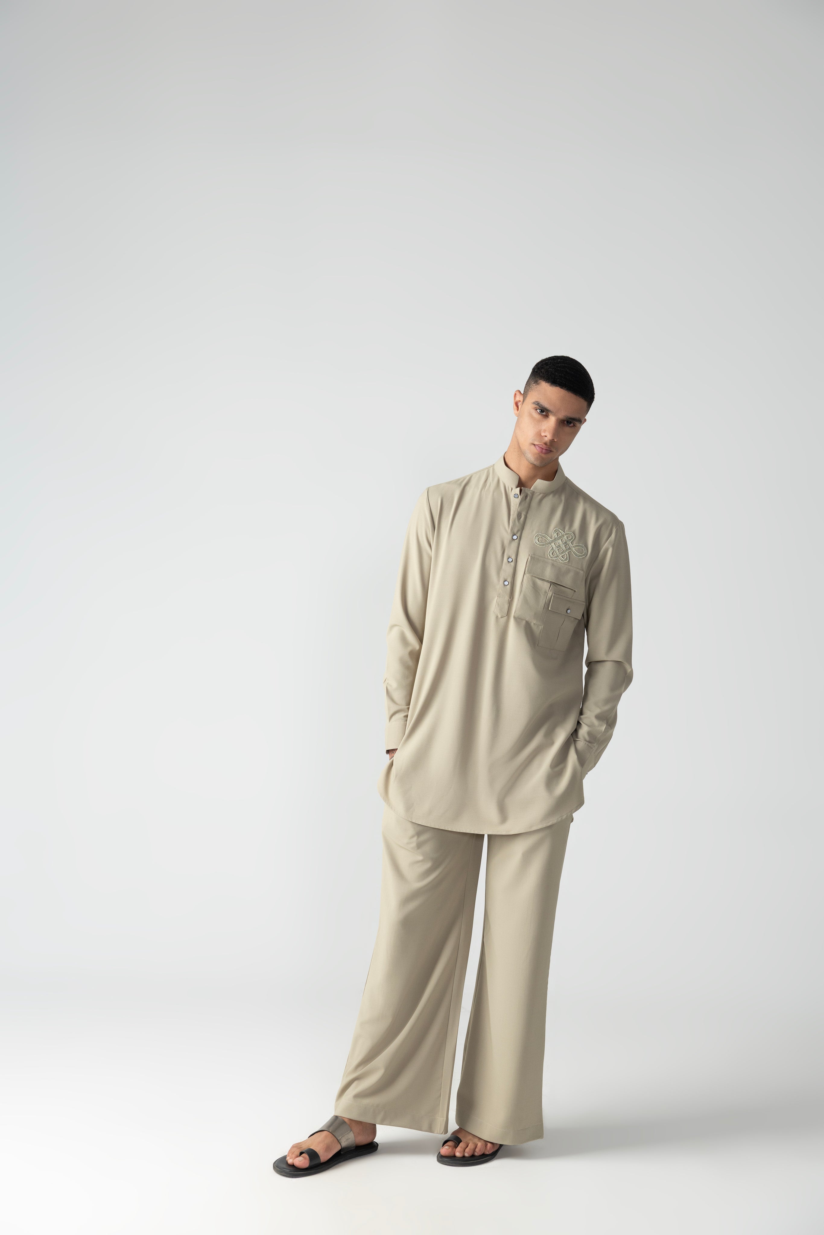 Beige short crepe kurta with patch pocket & thread embroidery detailing, paired with a matching plazzo.