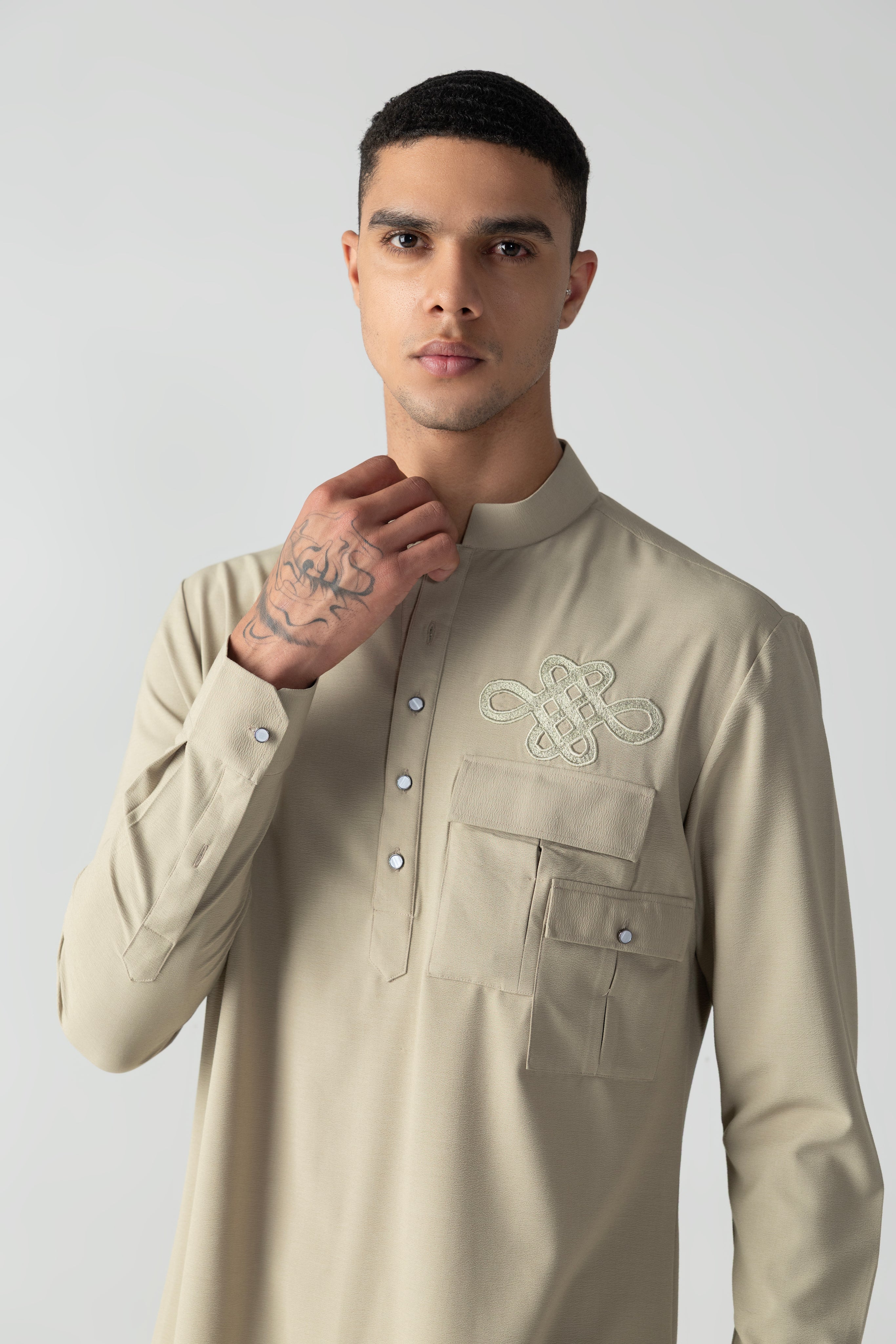 Beige short crepe kurta with patch pocket & thread embroidery detailing, paired with a matching plazzo.