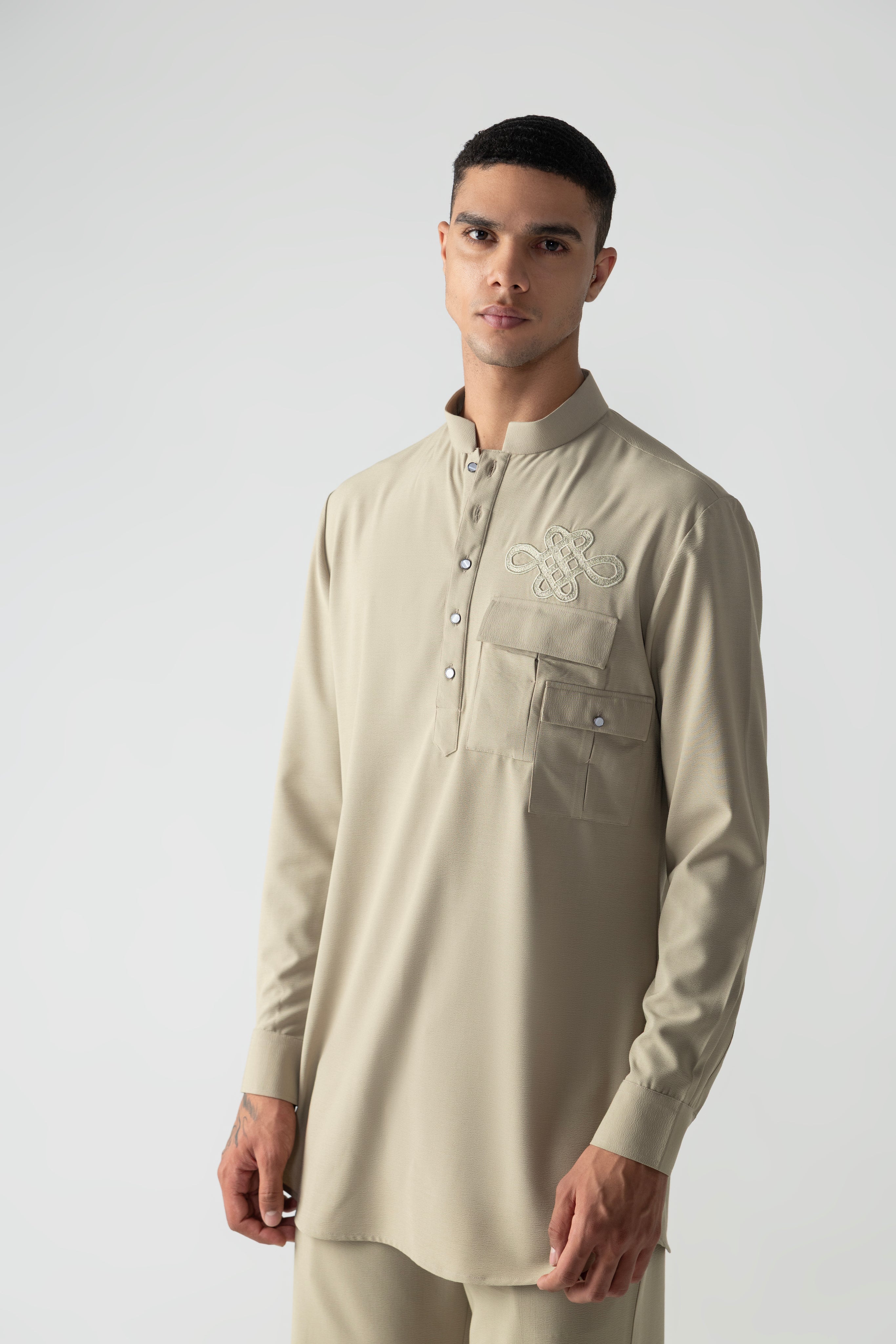 Beige short crepe kurta with patch pocket & thread embroidery detailing, paired with a matching plazzo.