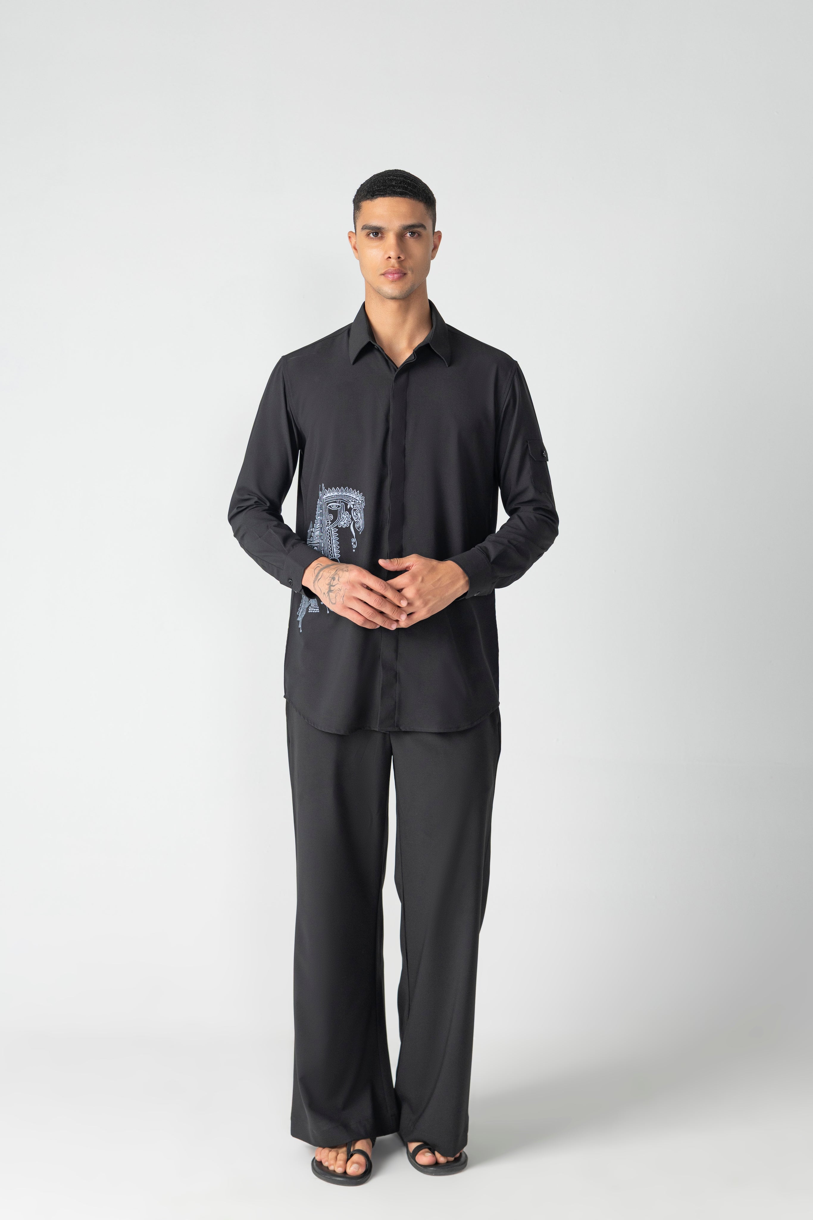 Black crepe shirt with hidden button placket and thread embroidery detailing, paired with a matching plazzo