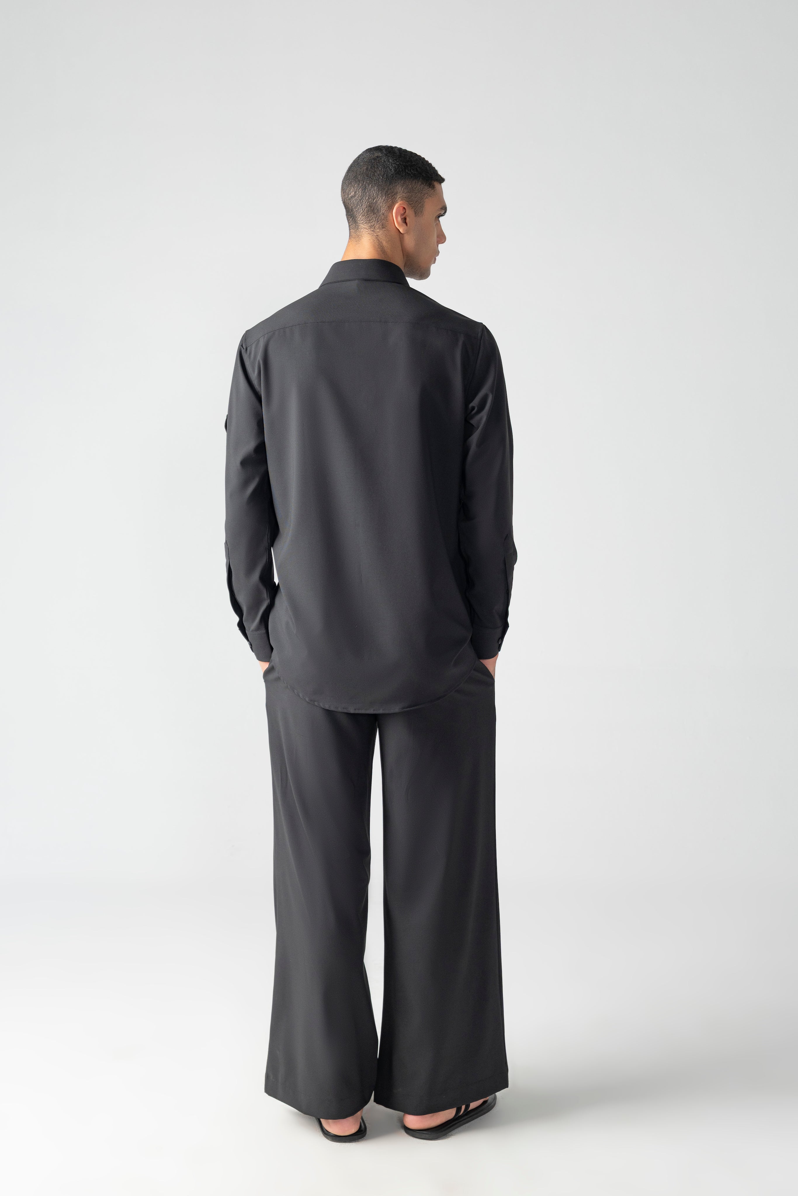 Black crepe shirt with hidden button placket and thread embroidery detailing, paired with a matching plazzo