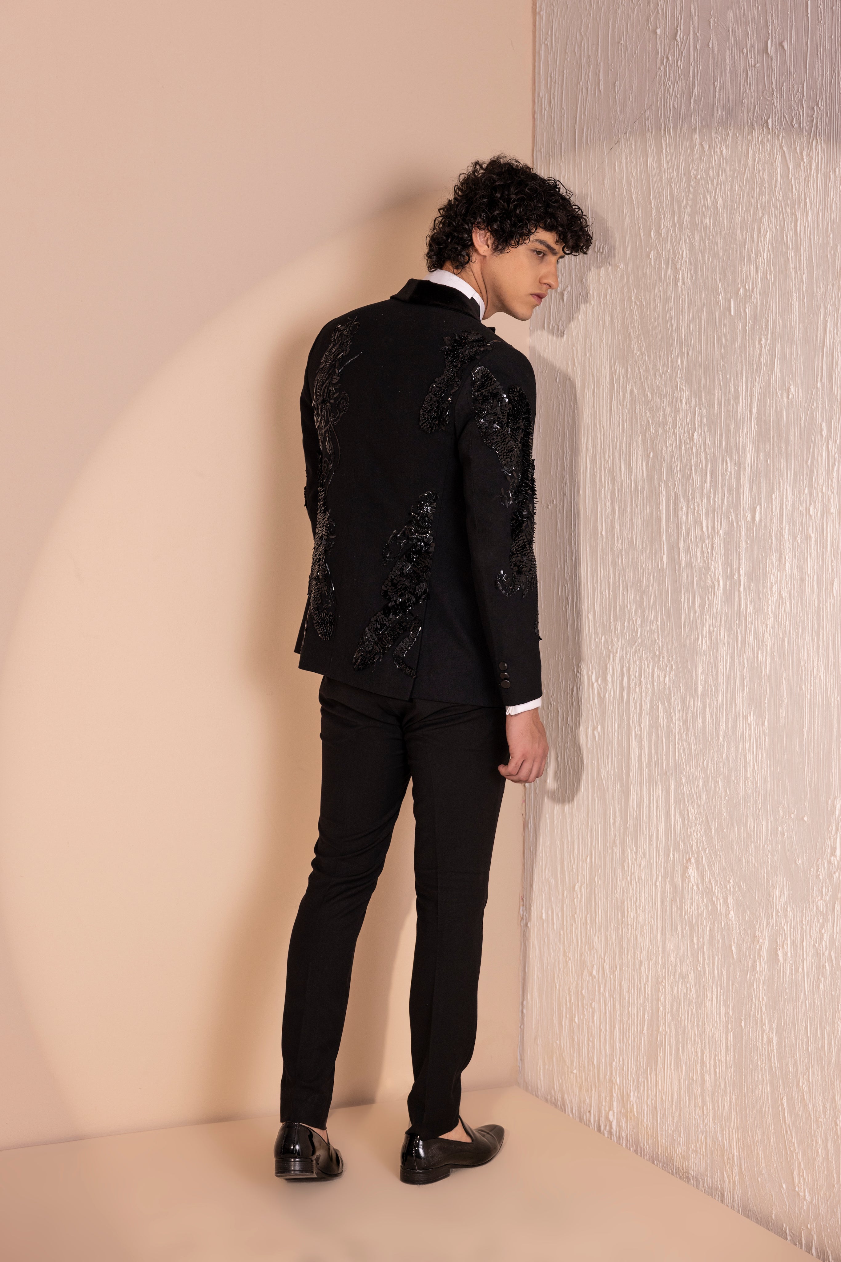 Hand embroidered motif tuxedo jacket paired with matching pants.