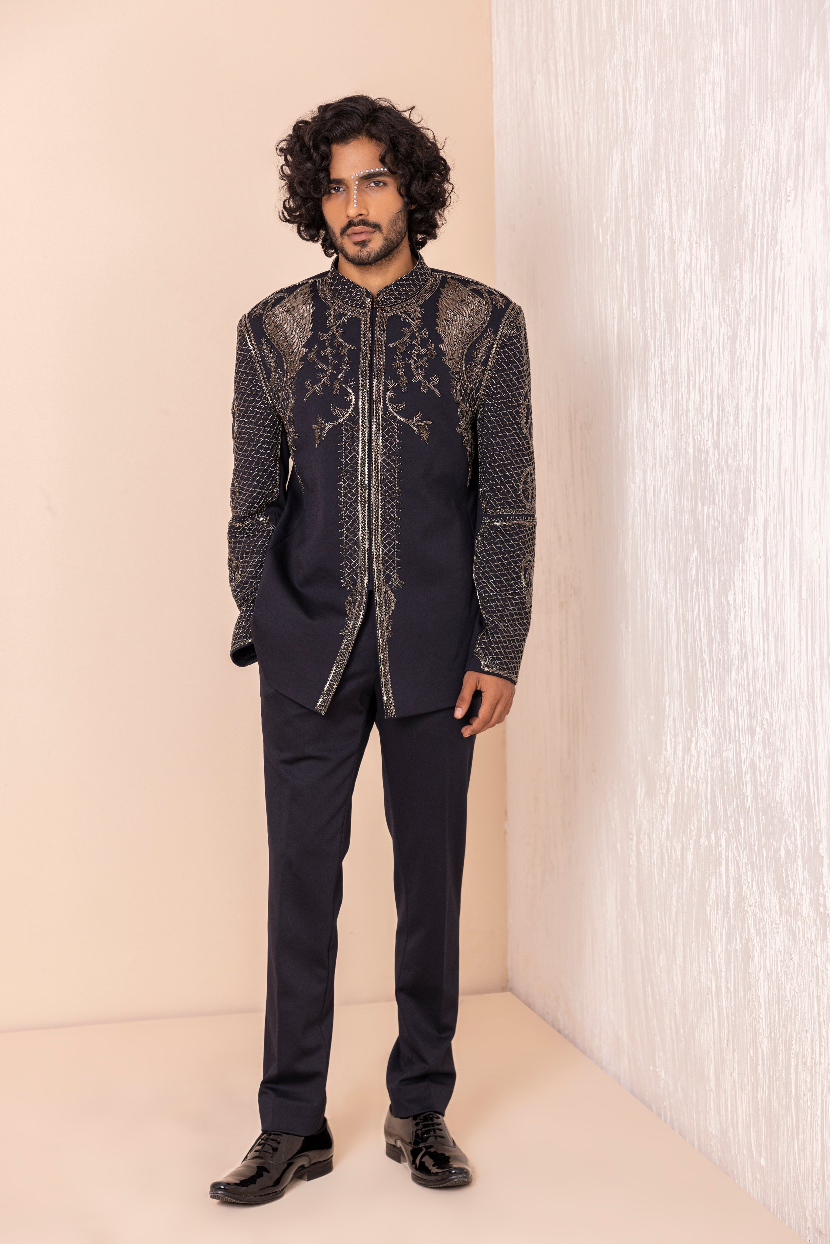 Hand embroidered coat with detailed metal work paired with matching pants.