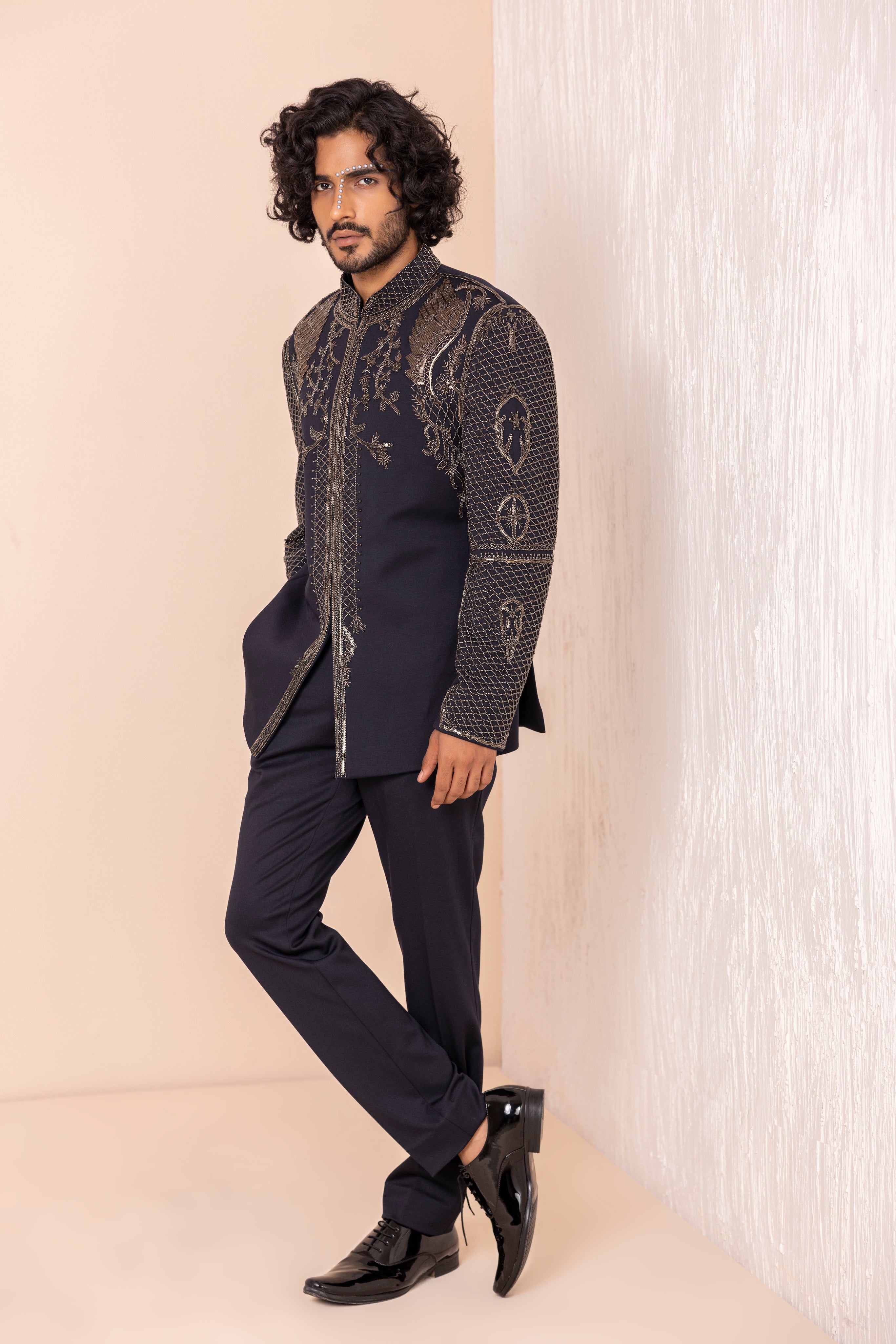 Hand embroidered coat with detailed metal work paired with matching pants.
