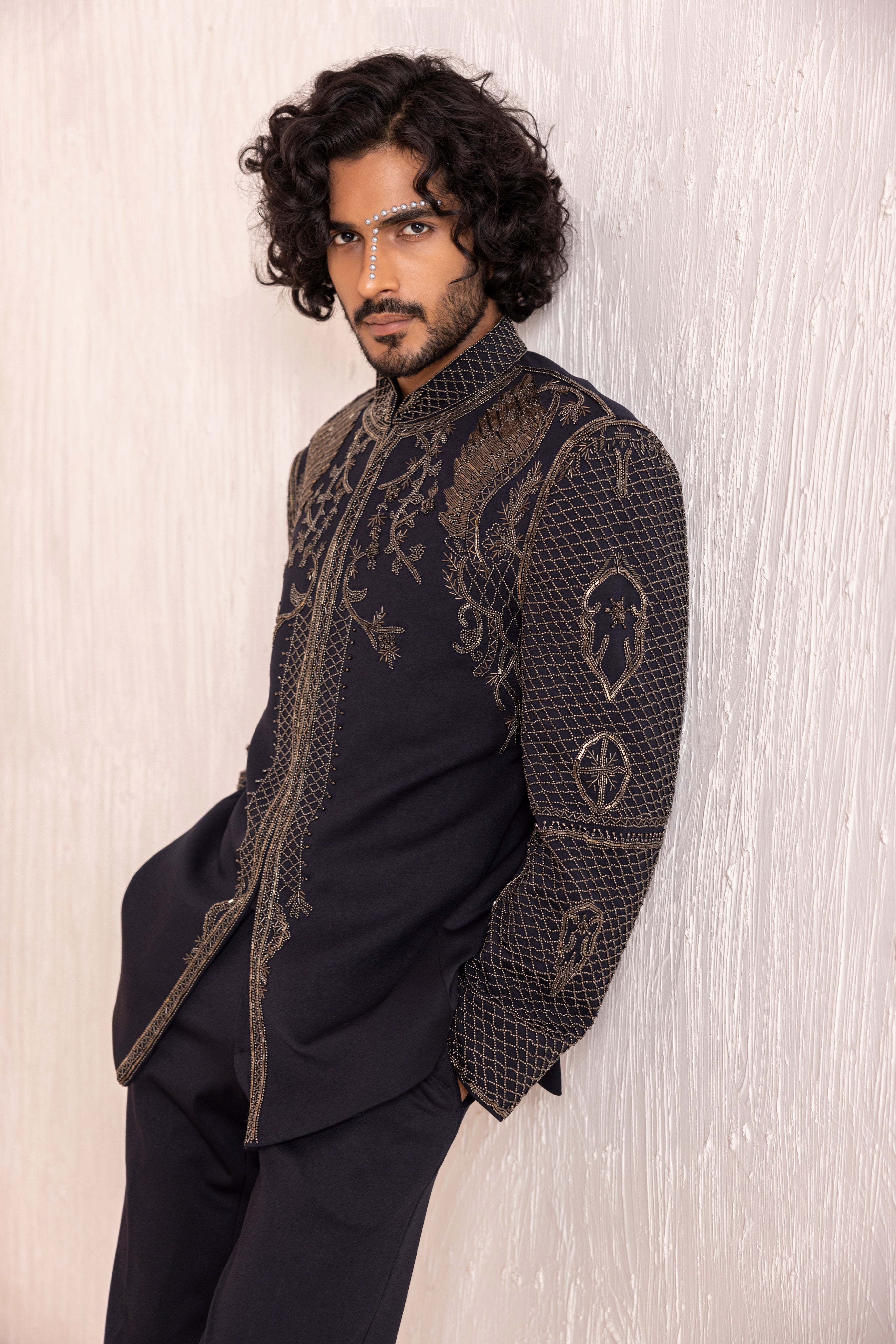 Hand embroidered coat with detailed metal work paired with matching pants.