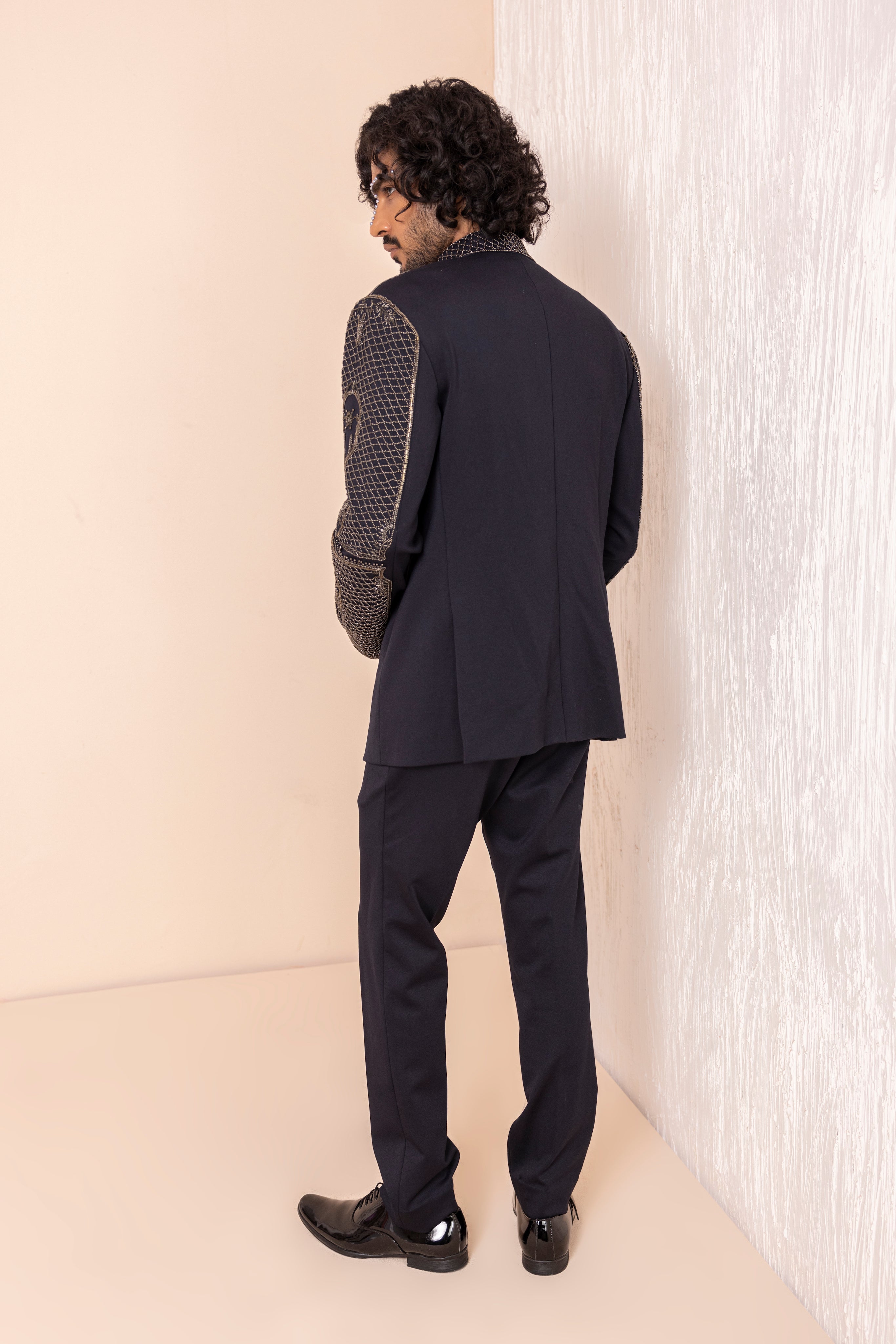 Hand embroidered coat with detailed metal work paired with matching pants.