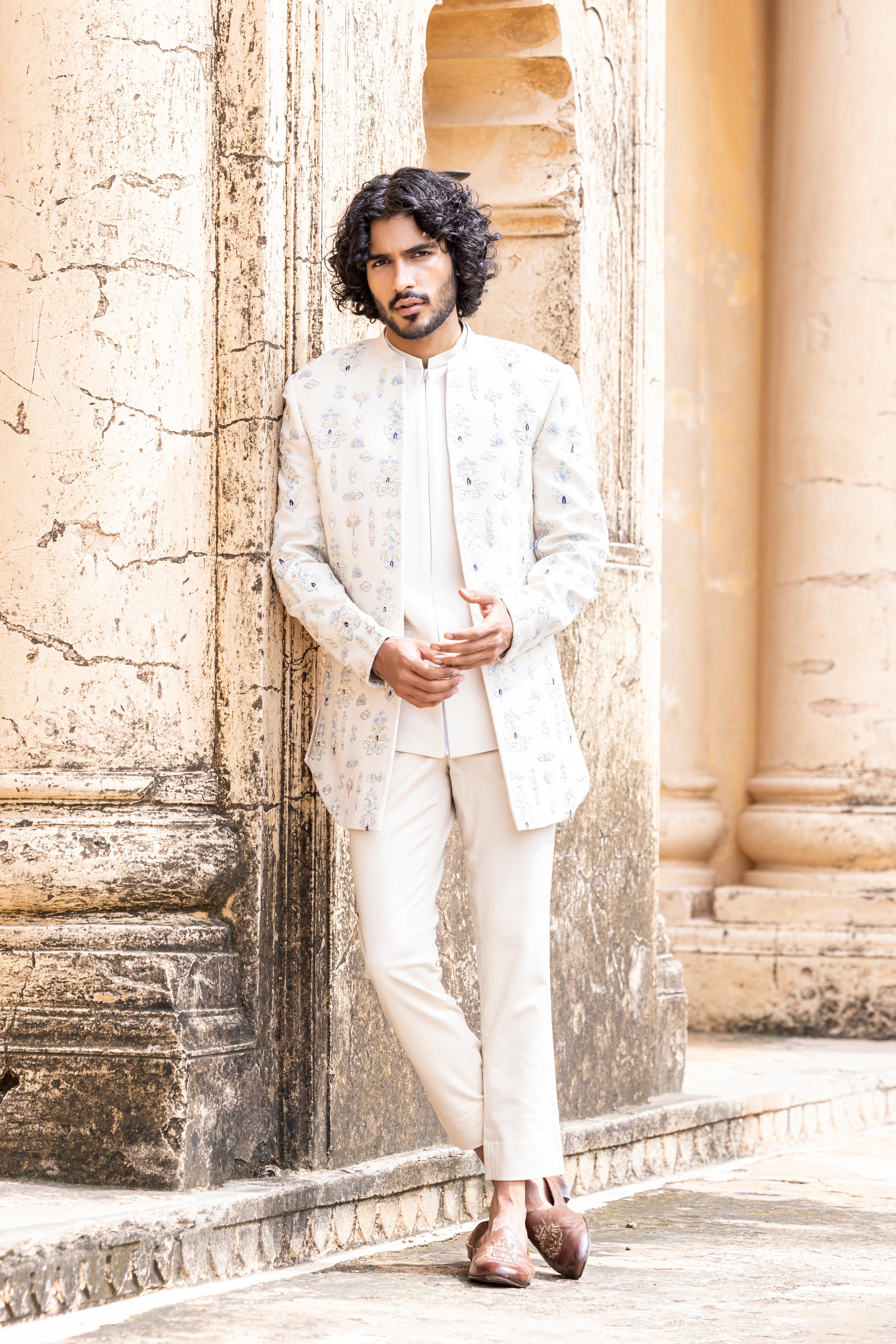 Cream front-open indowestern jacket embellished with hand embroidered pastel motifs paired with a zipper waistcoat and pants.