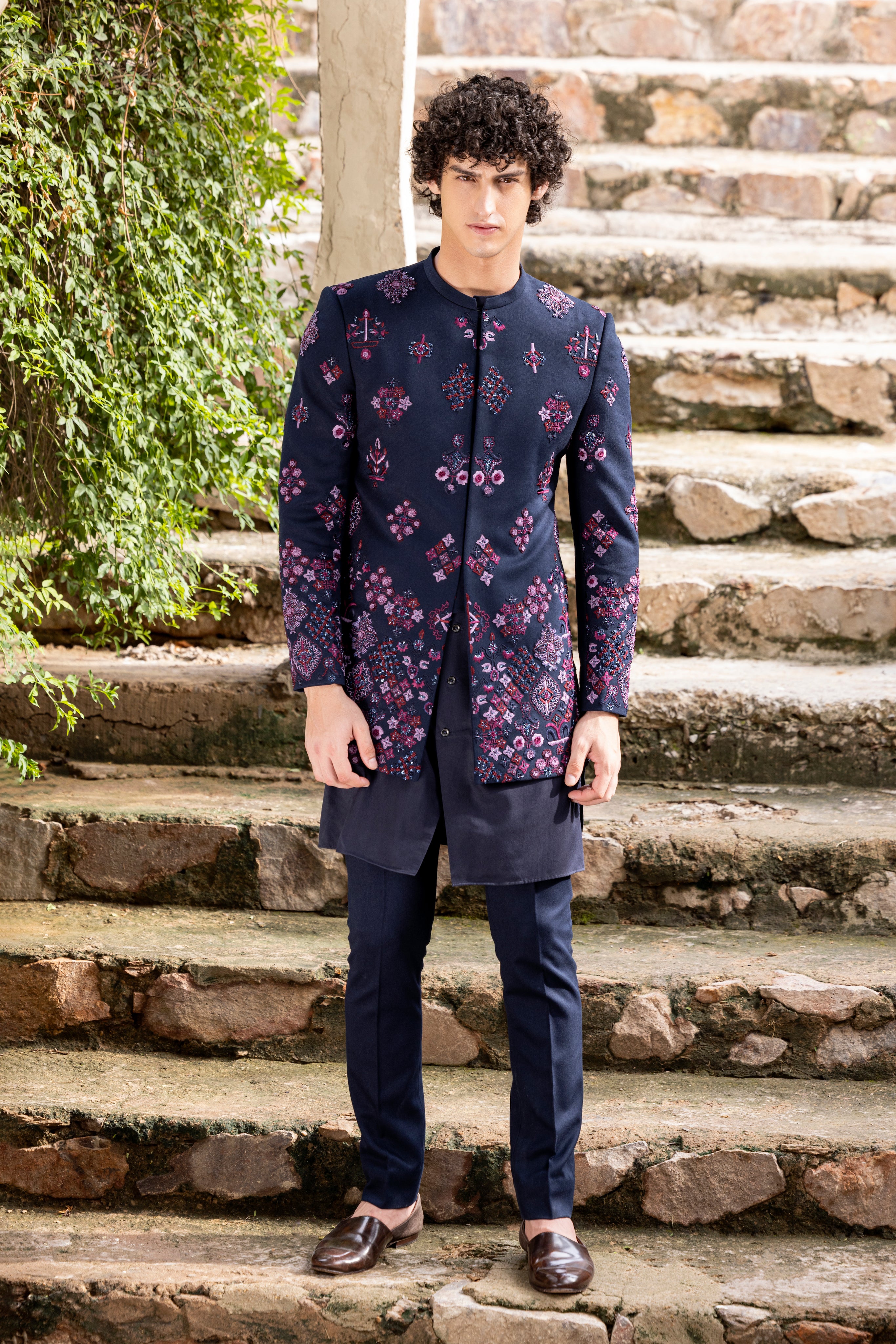Navy Blue indowestern jacket embellished with multicoloured hand embroidered motifs paired with matching kurta and pants.