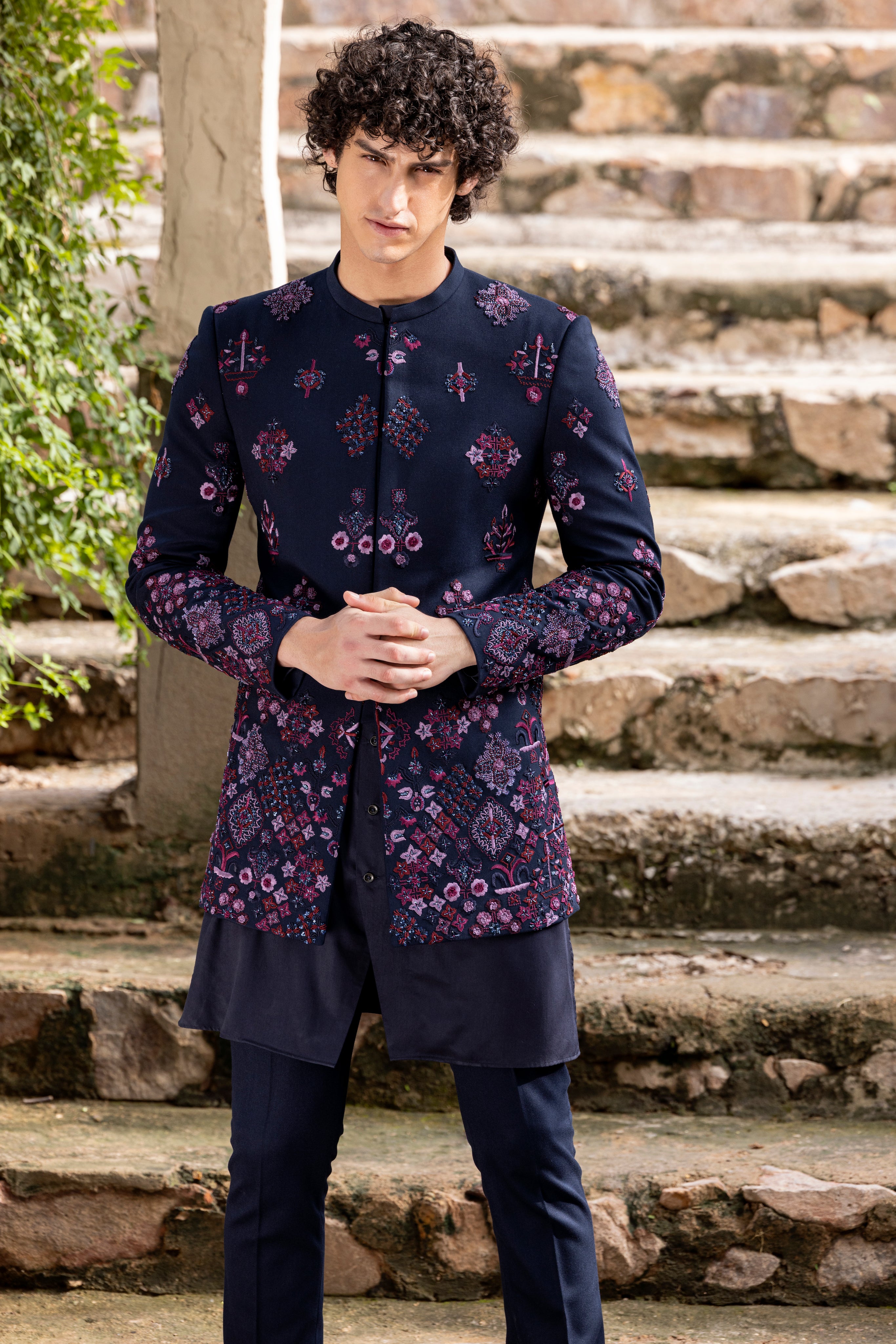 Navy Blue indowestern jacket embellished with multicoloured hand embroidered motifs paired with matching kurta and pants.