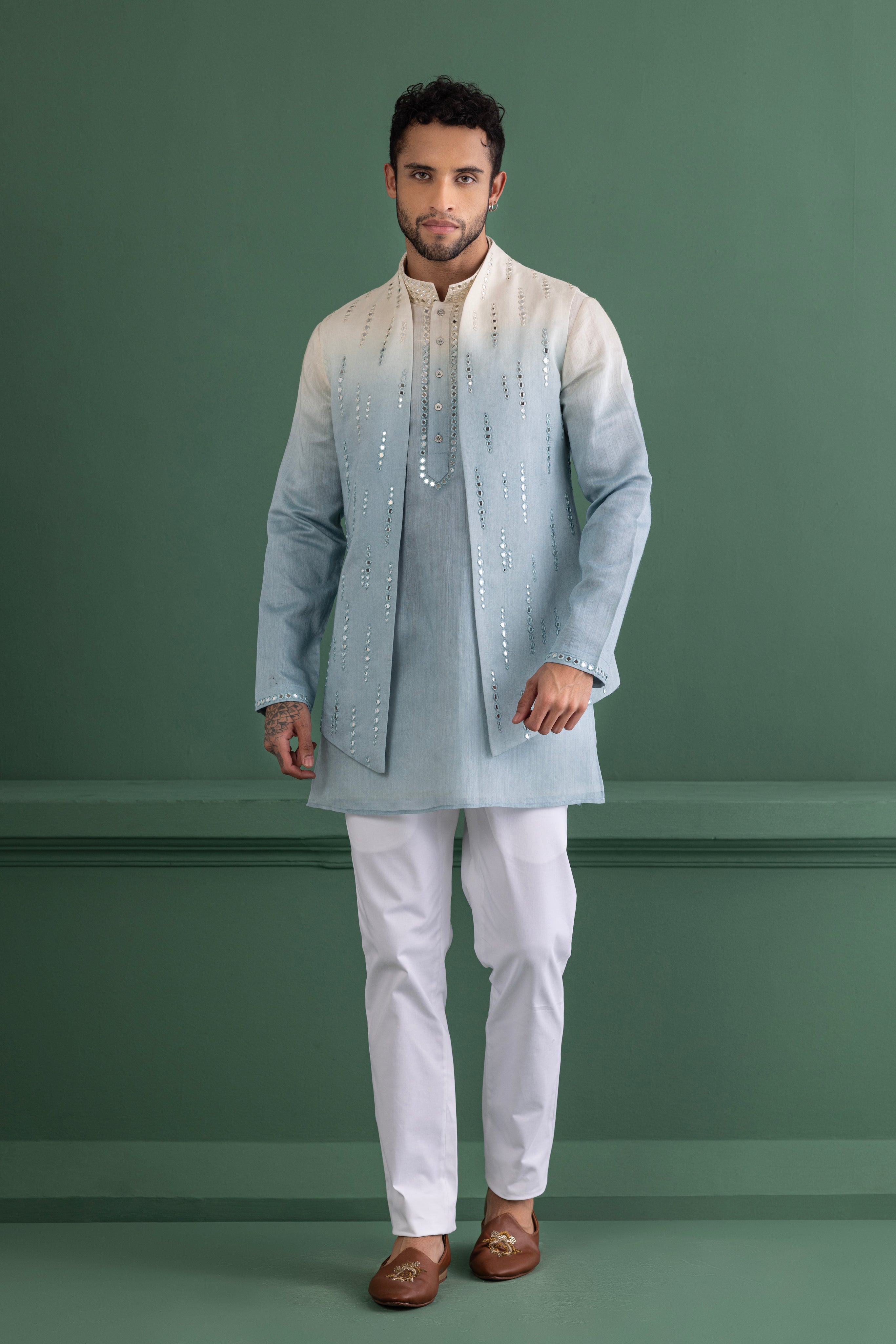 Sky blue shaded waistcoat with mirror work paired with a matching kurta and off-white aligadhi