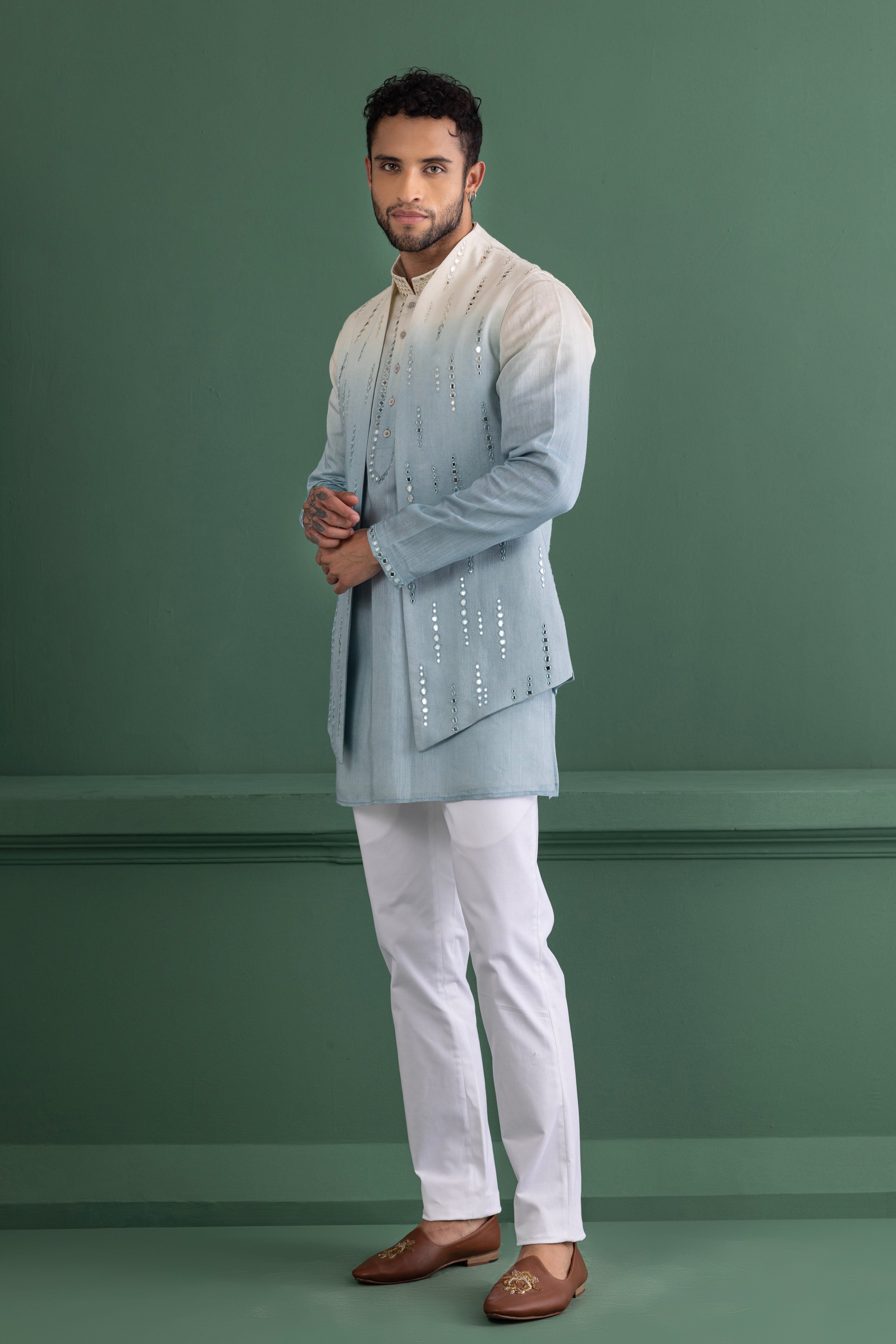 Sky blue shaded waistcoat with mirror work paired with a matching kurta and off-white aligadhi