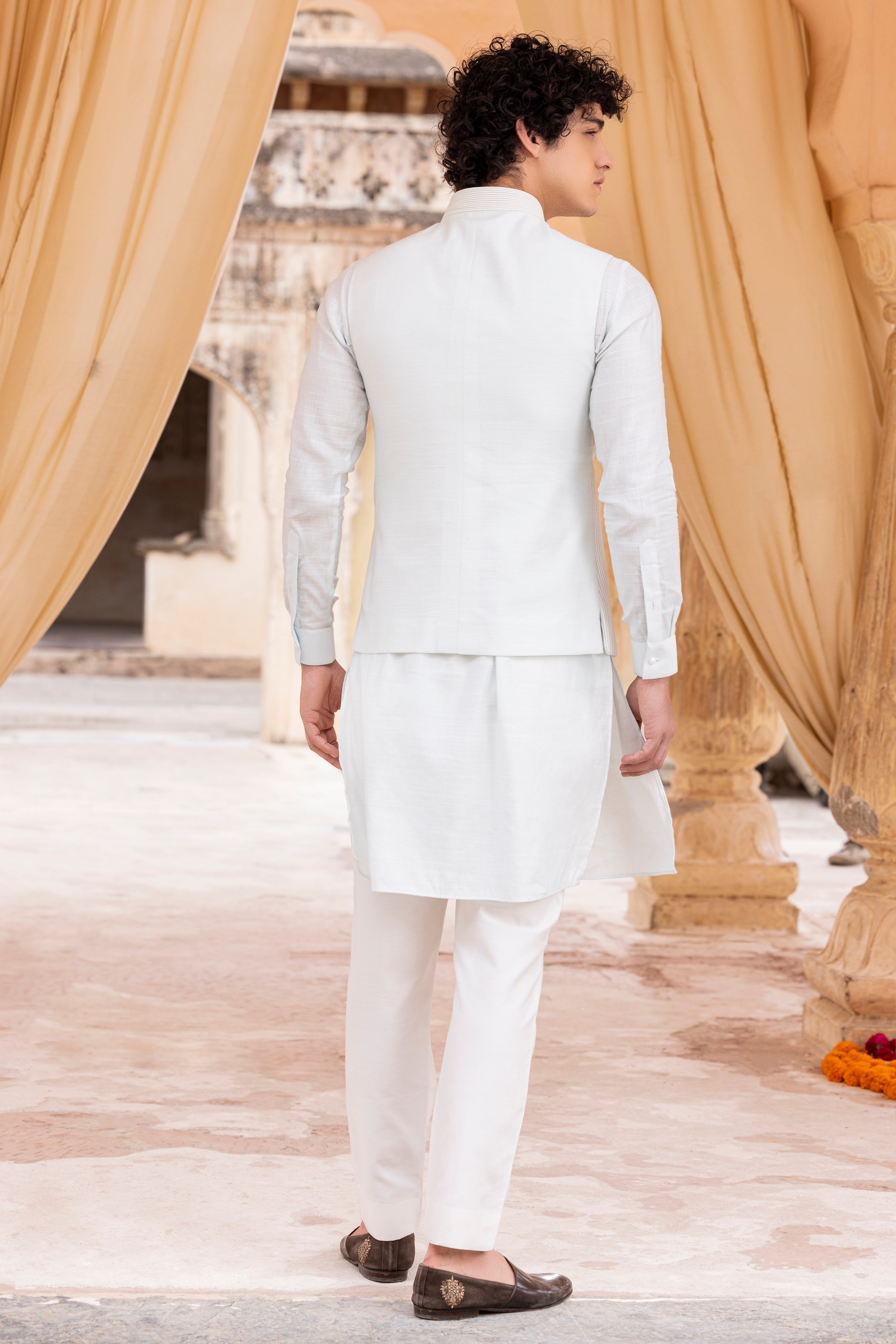 Leather work waistcoat paired with kurta and aligadhi.