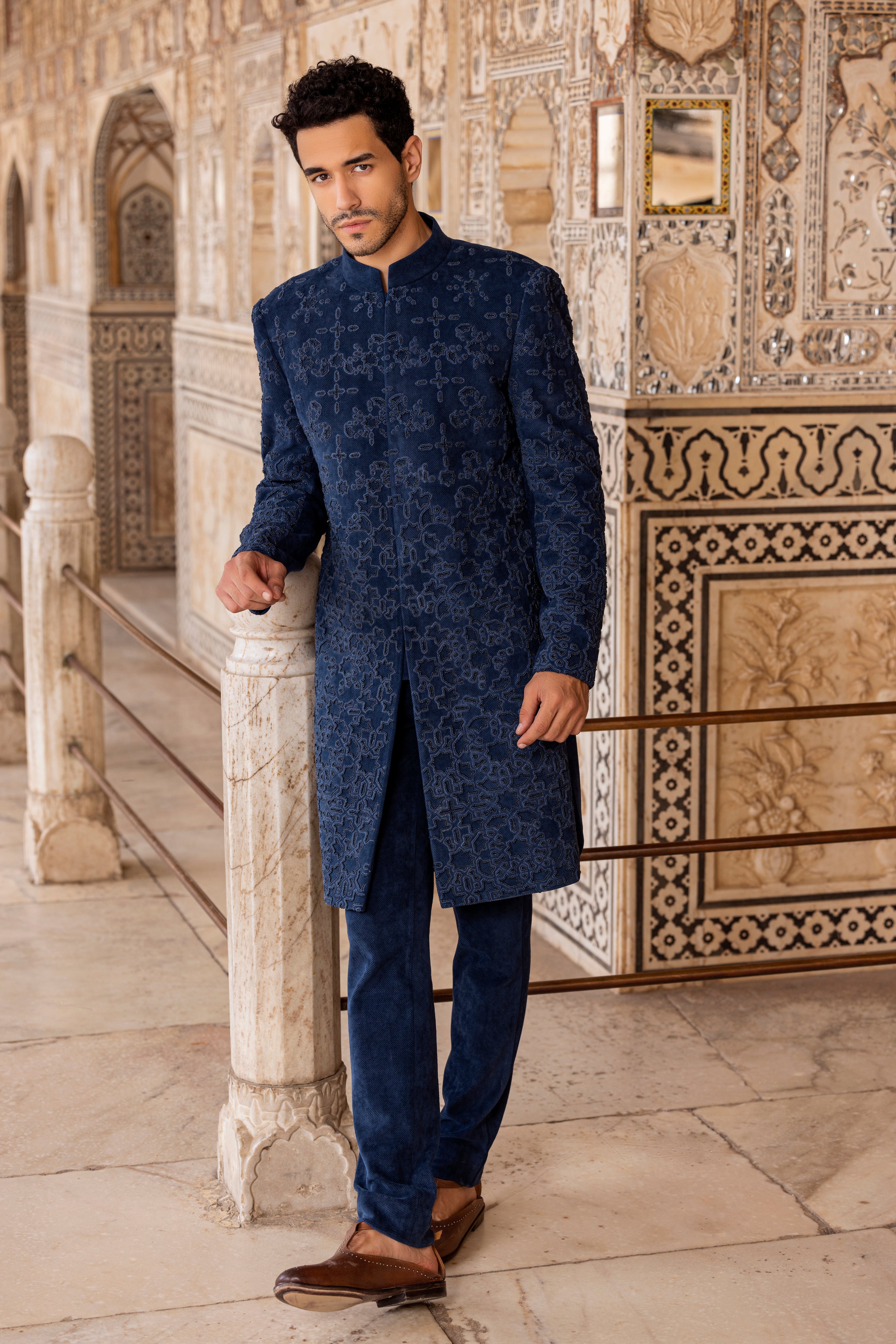 Blue long indowestern jacket highlighted with intricate French knot and moti hand embroidery paired with pants.