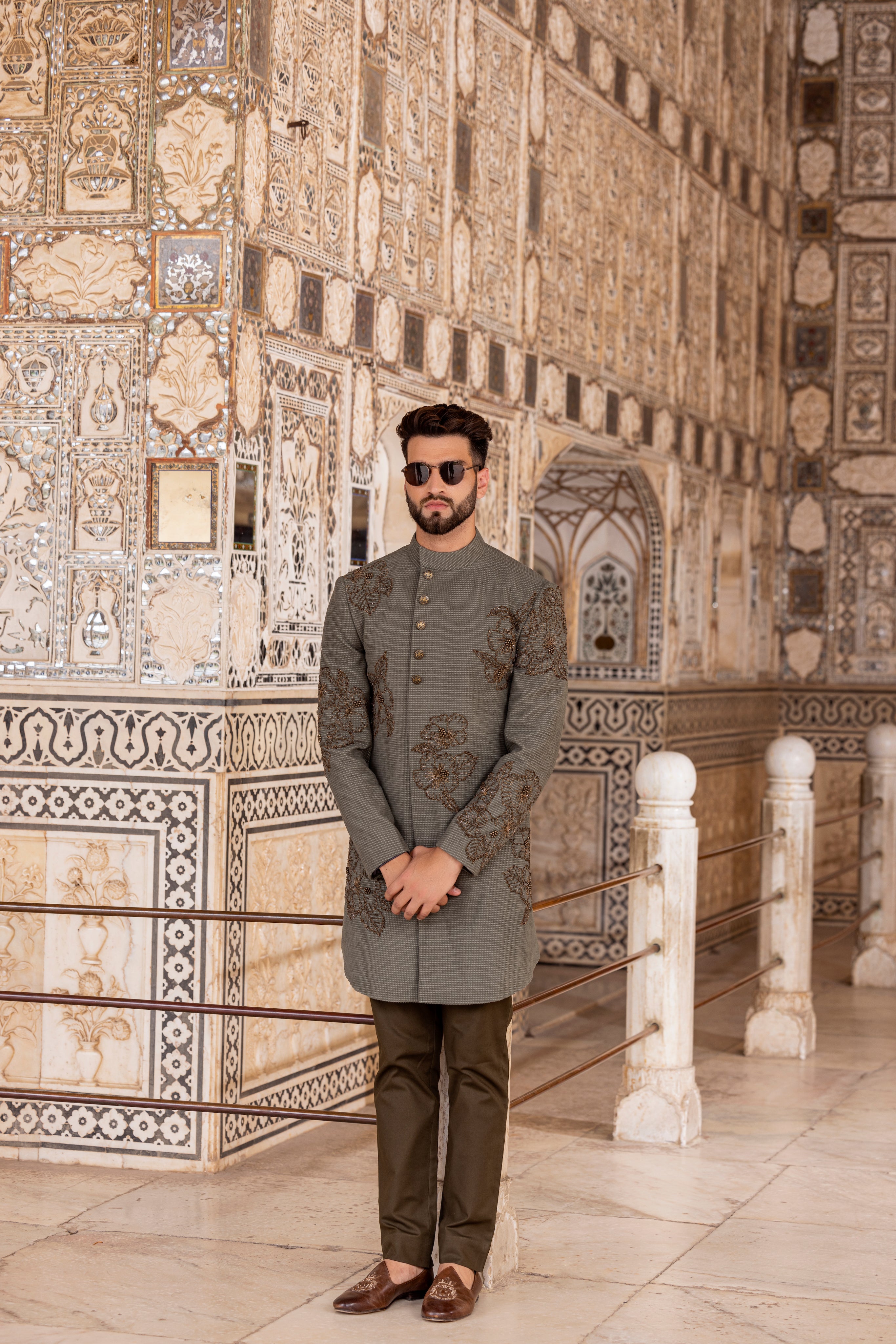 Olive green textured suede indowestern jacket embellished using metal work paired with pants.