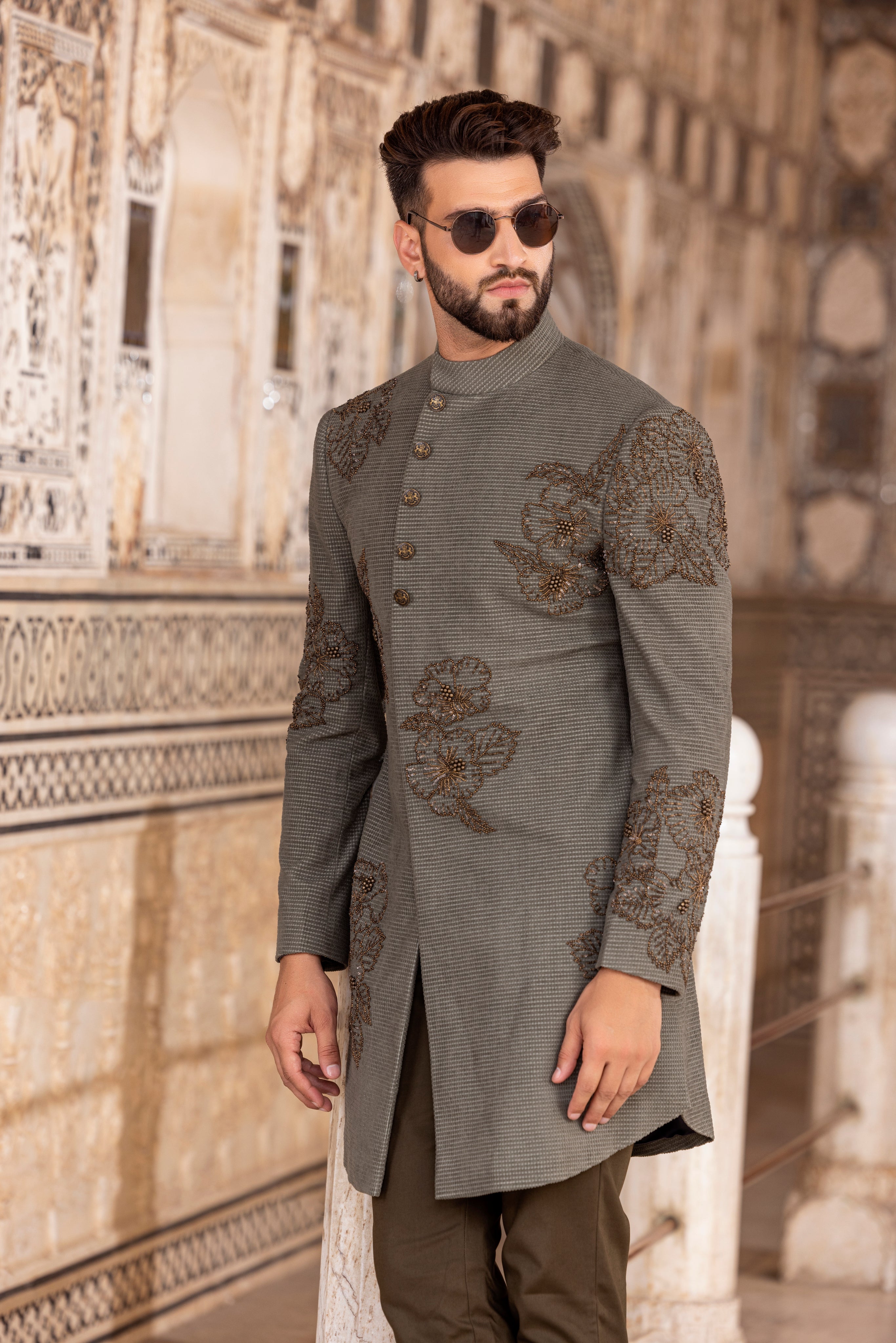 Olive green textured suede indowestern jacket embellished using metal work paired with pants.