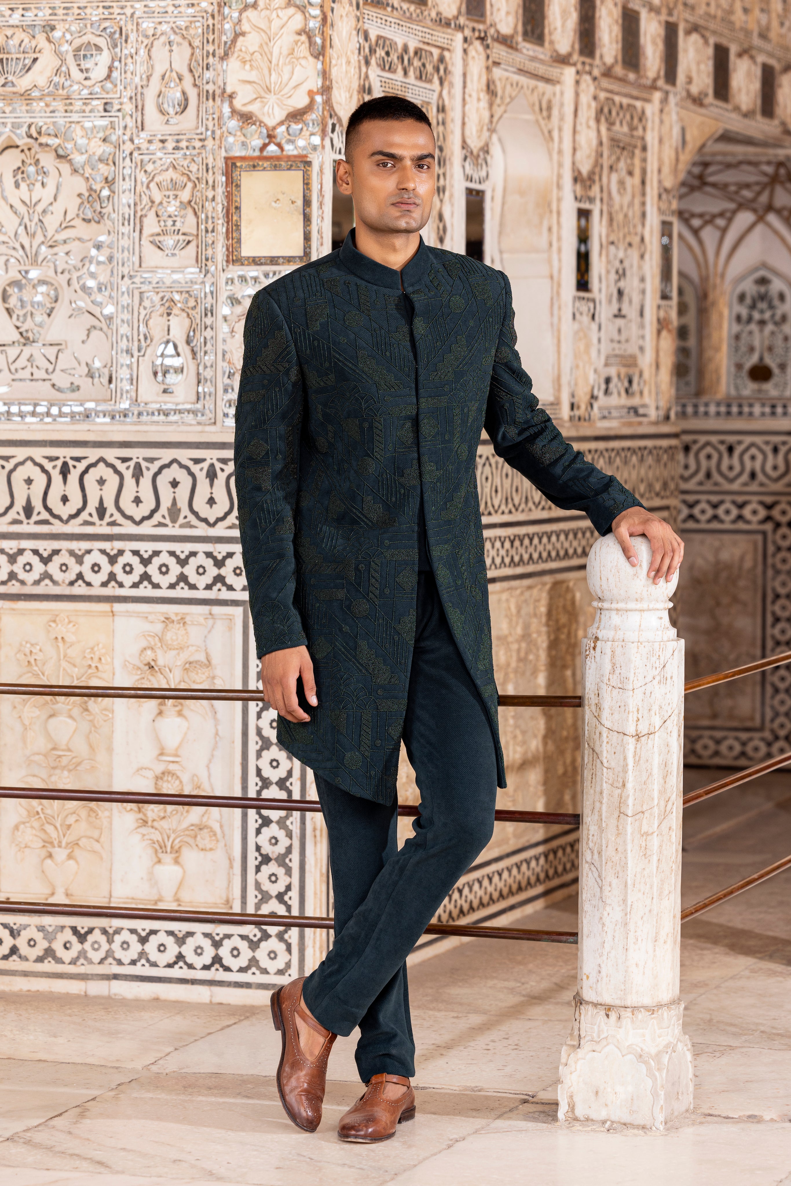 Bottle Green long indowestern jacket highlighted with intricate hand embroidery paired with pants.