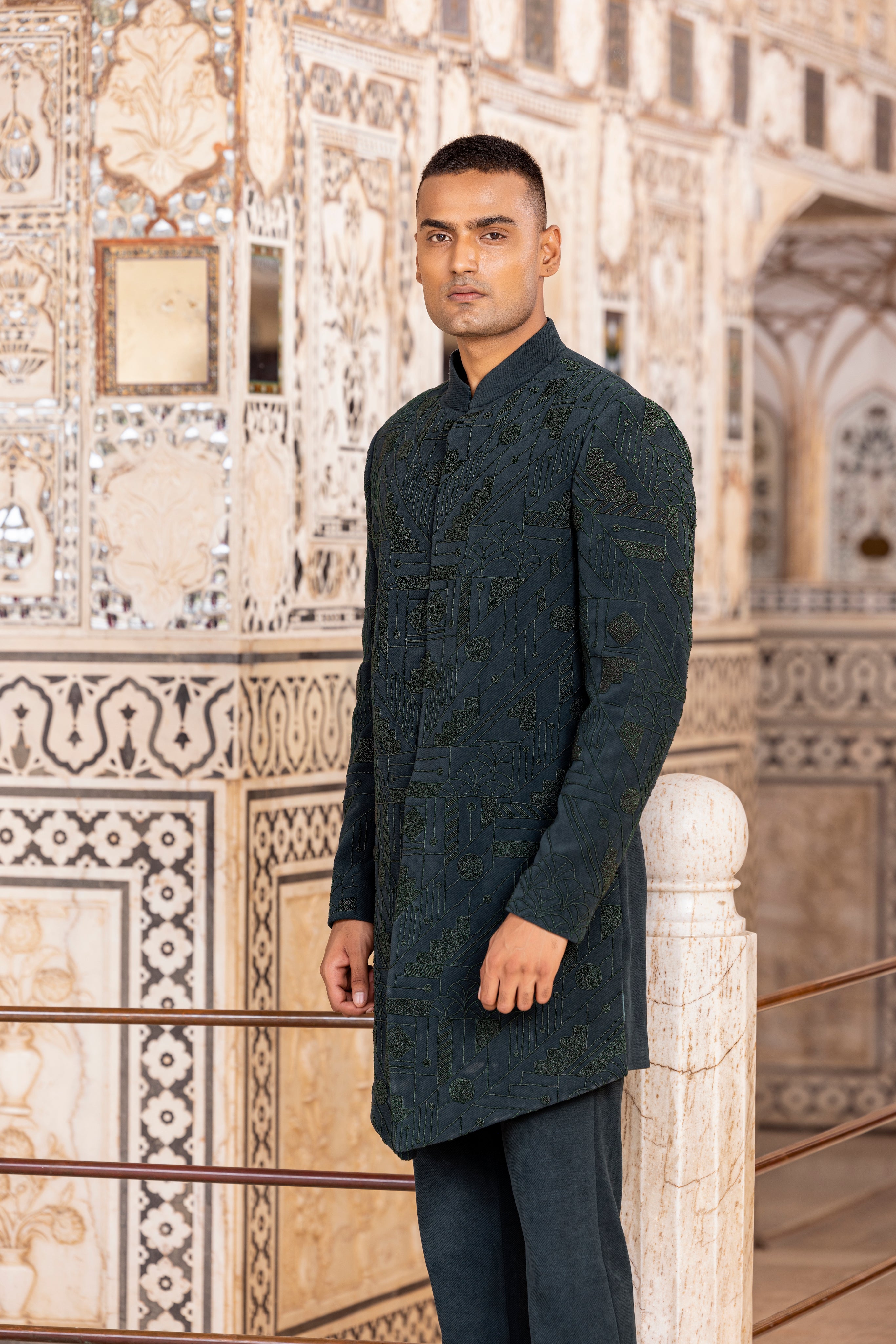 Bottle Green long indowestern jacket highlighted with intricate hand embroidery paired with pants.