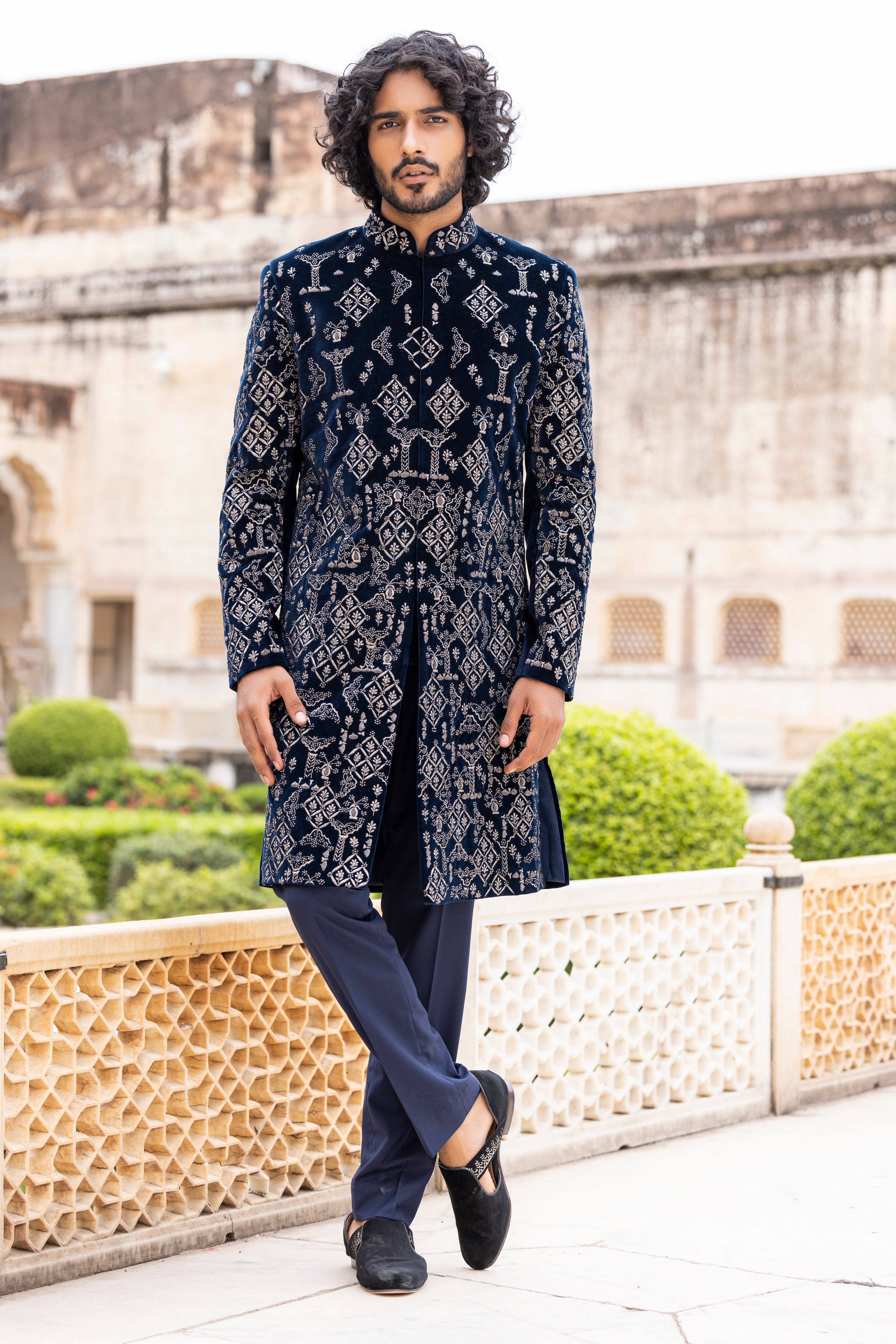 Navy Blue velvet long indowestern jacket highlighted with zari and dabka hand embroidery paired with pants.