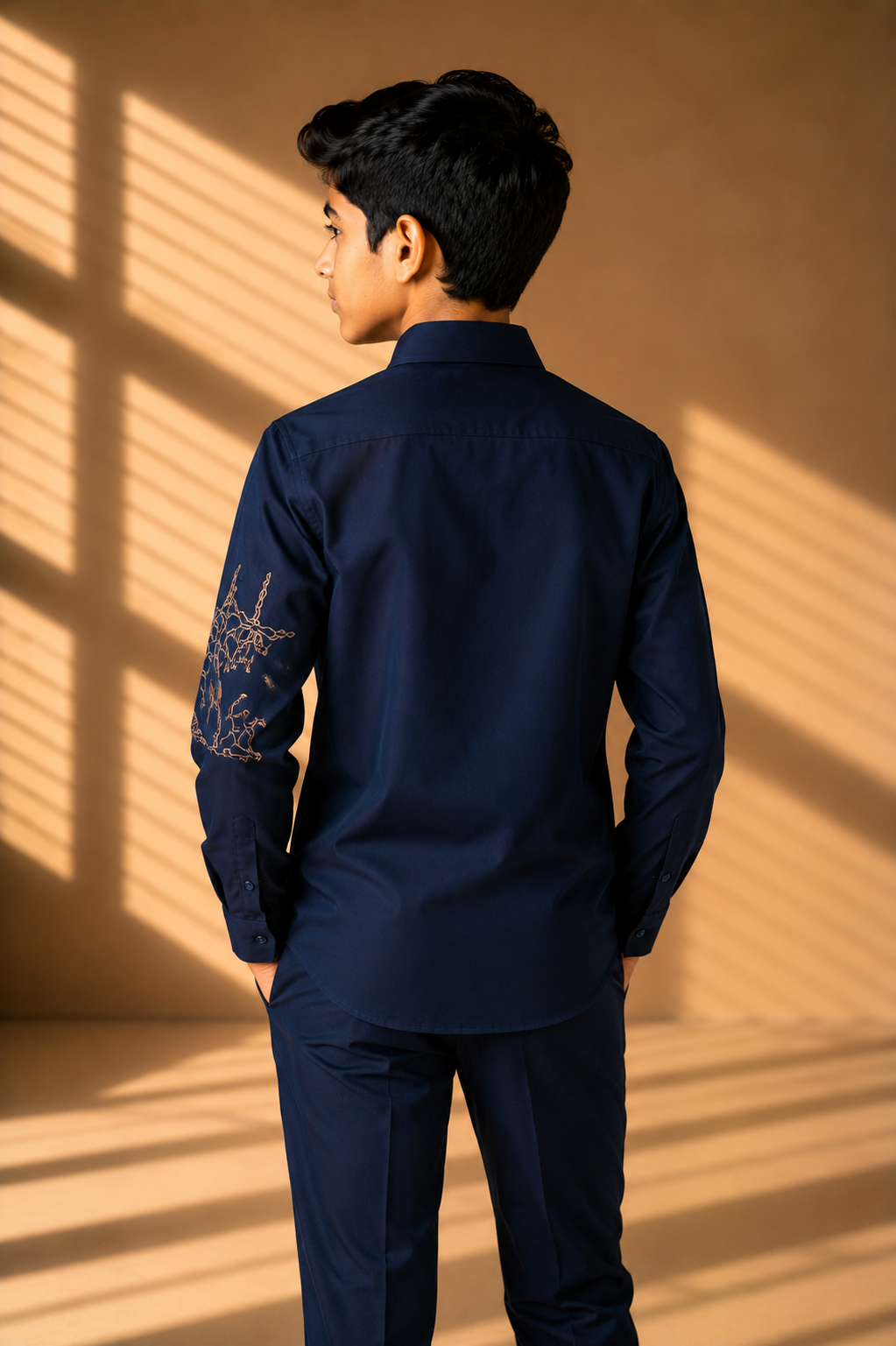 Navy blue shirt with hand-embroidered metallic motif on sleeve