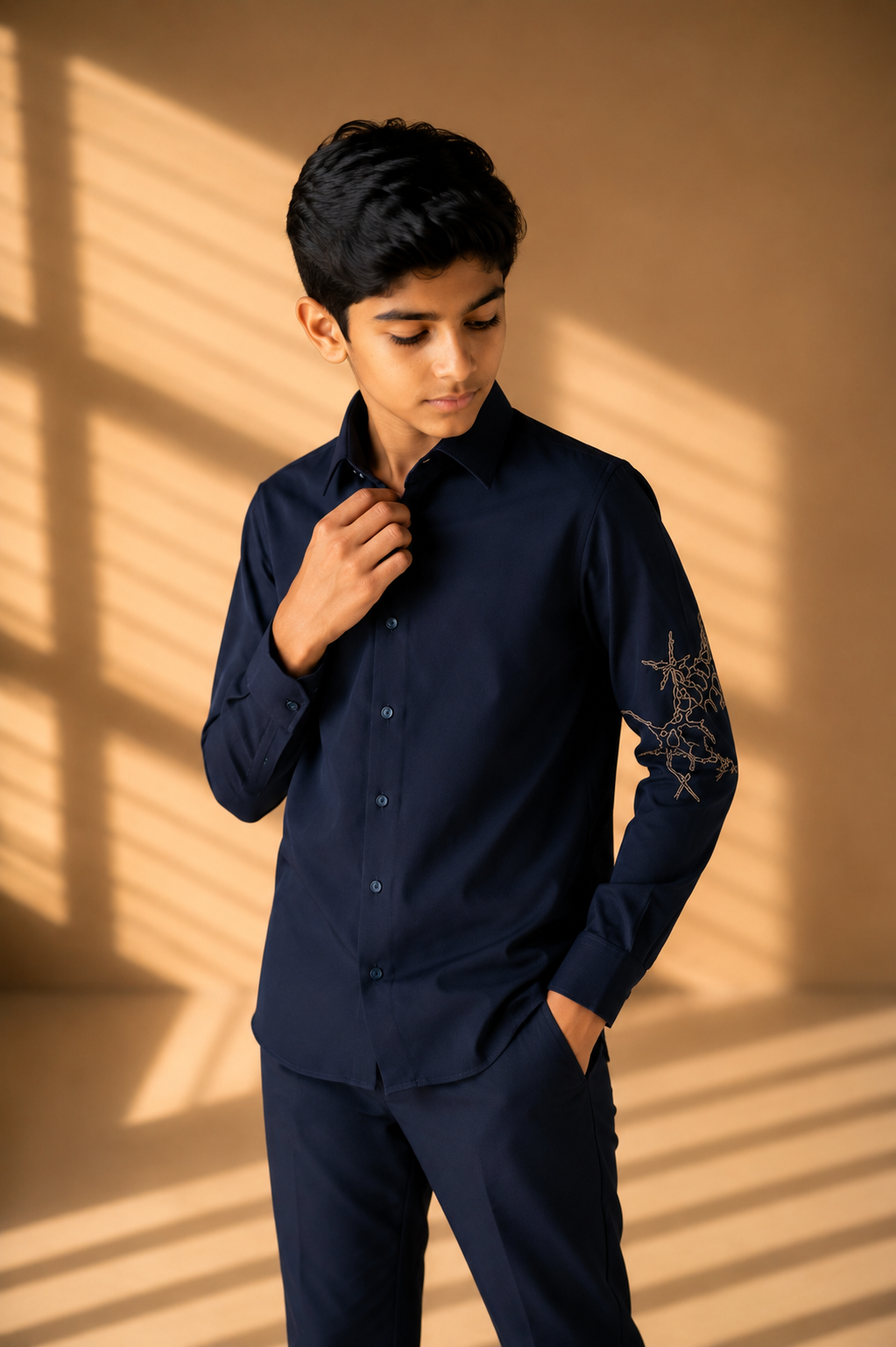 Navy blue shirt with hand-embroidered metallic motif on sleeve