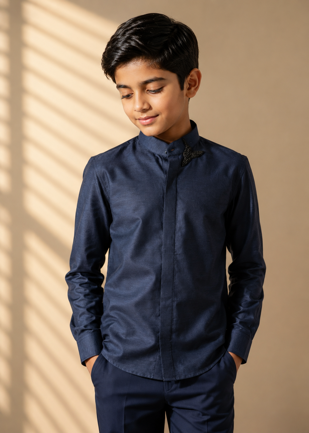 Blue knit shirt with hand-embroidered bird motif on Mandarin collar