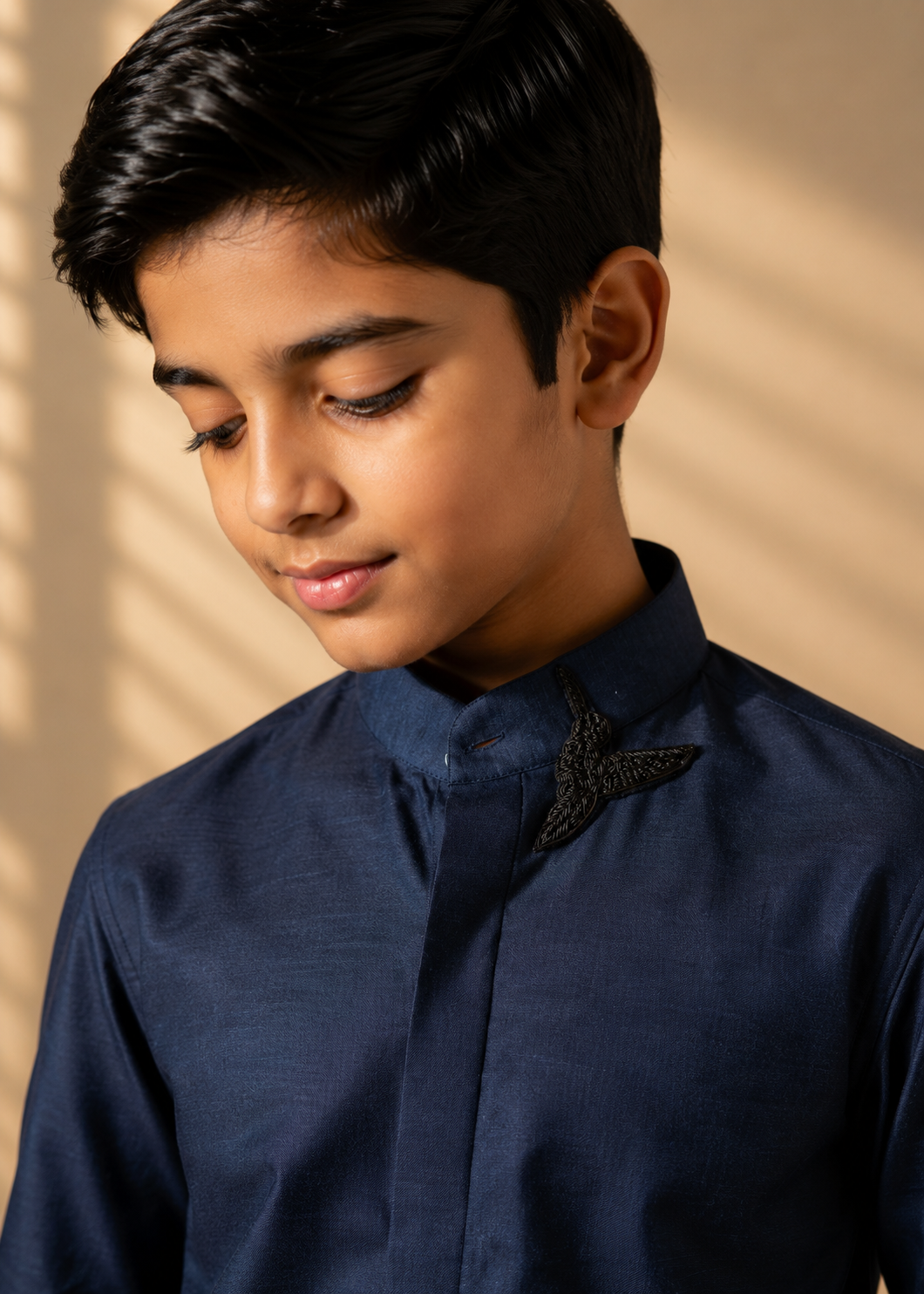 Blue knit shirt with hand-embroidered bird motif on Mandarin collar