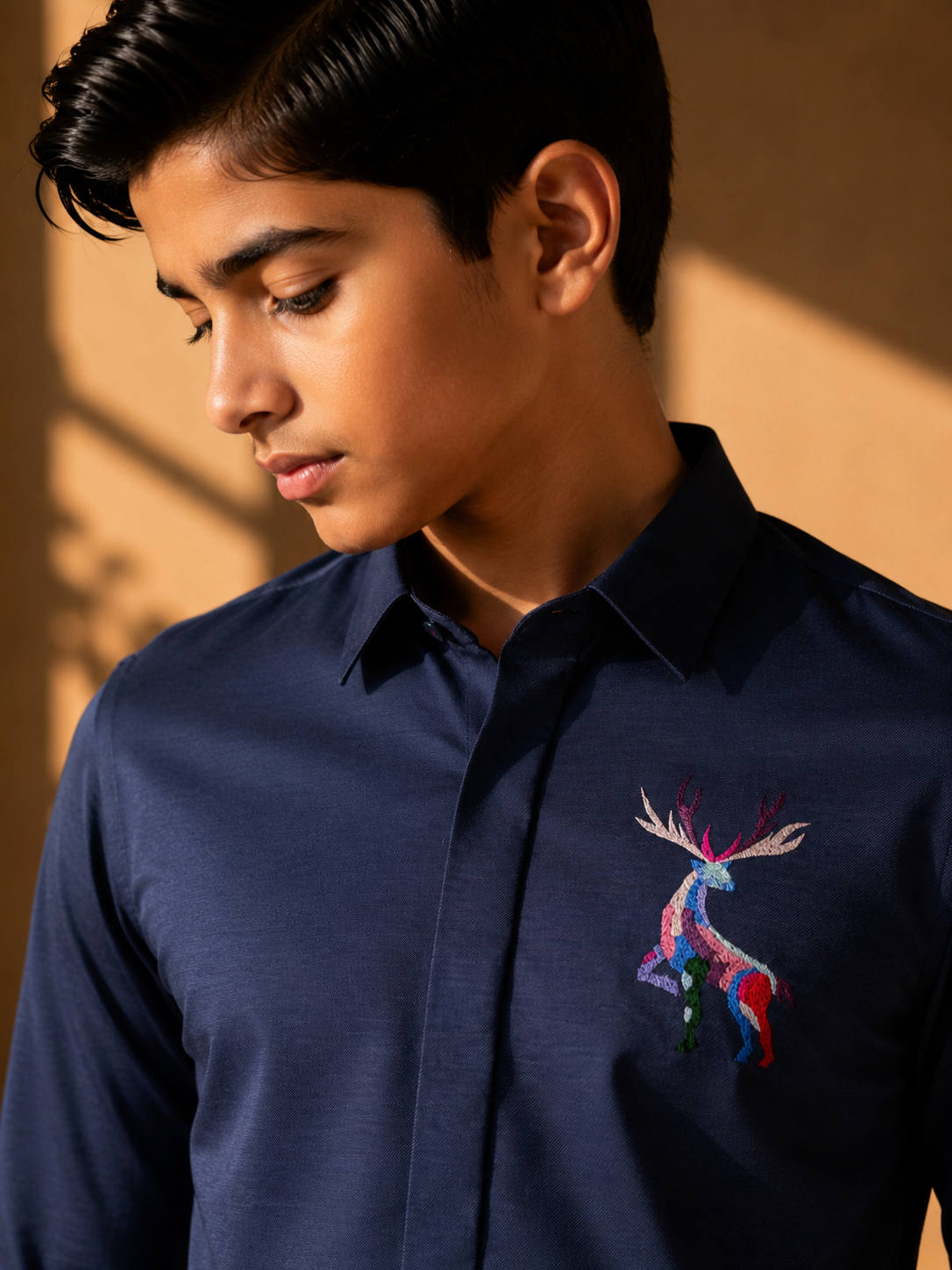 Navy blue knit shirt with embroidered multi-coloured Reindeer motif