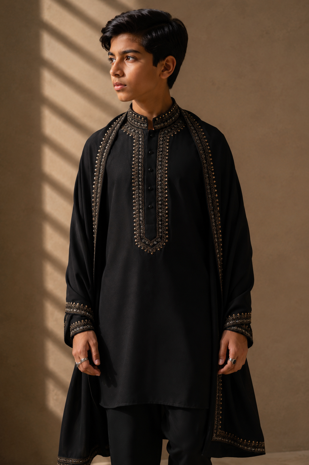 Featuring black knit kurta embelished with antique grey metal components around placket along with embroidered stole paired up with aligarhi pants.
