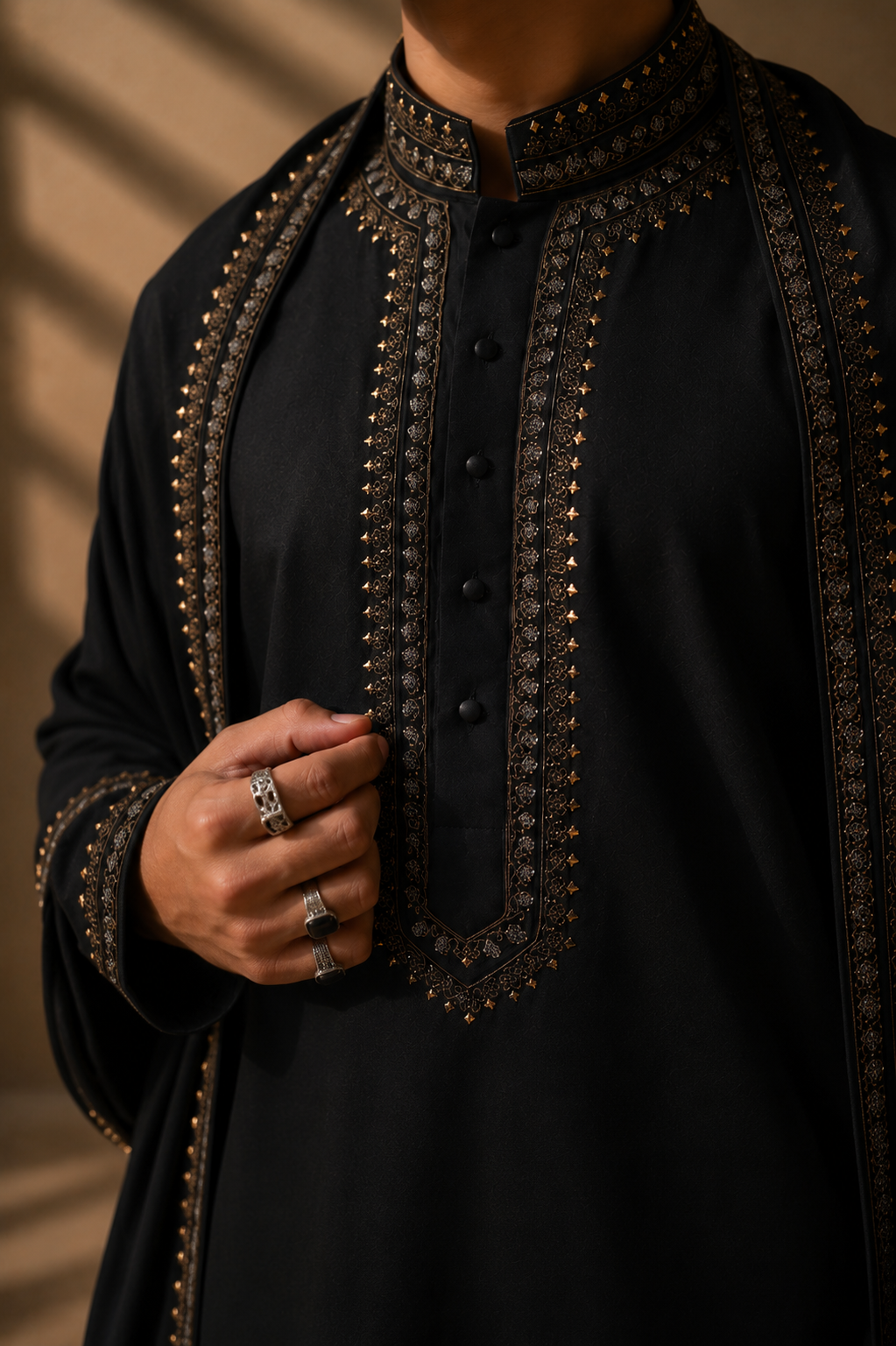 Featuring black knit kurta embelished with antique grey metal components around placket along with embroidered stole paired up with aligarhi pants.