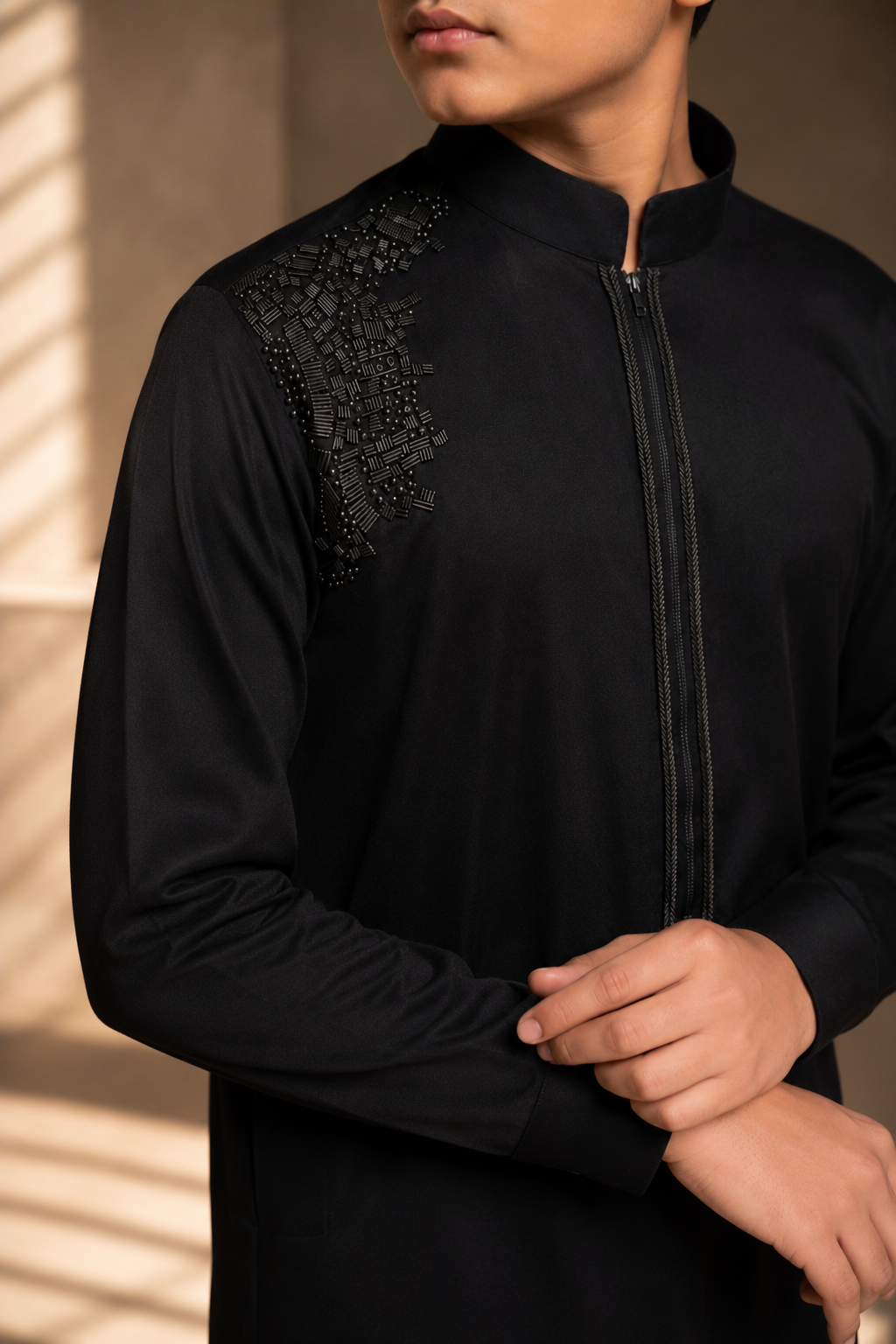 Featuring black knit kurta embellished with antique metal components on one shoulder and zipper detailing paired with aligarhi pants