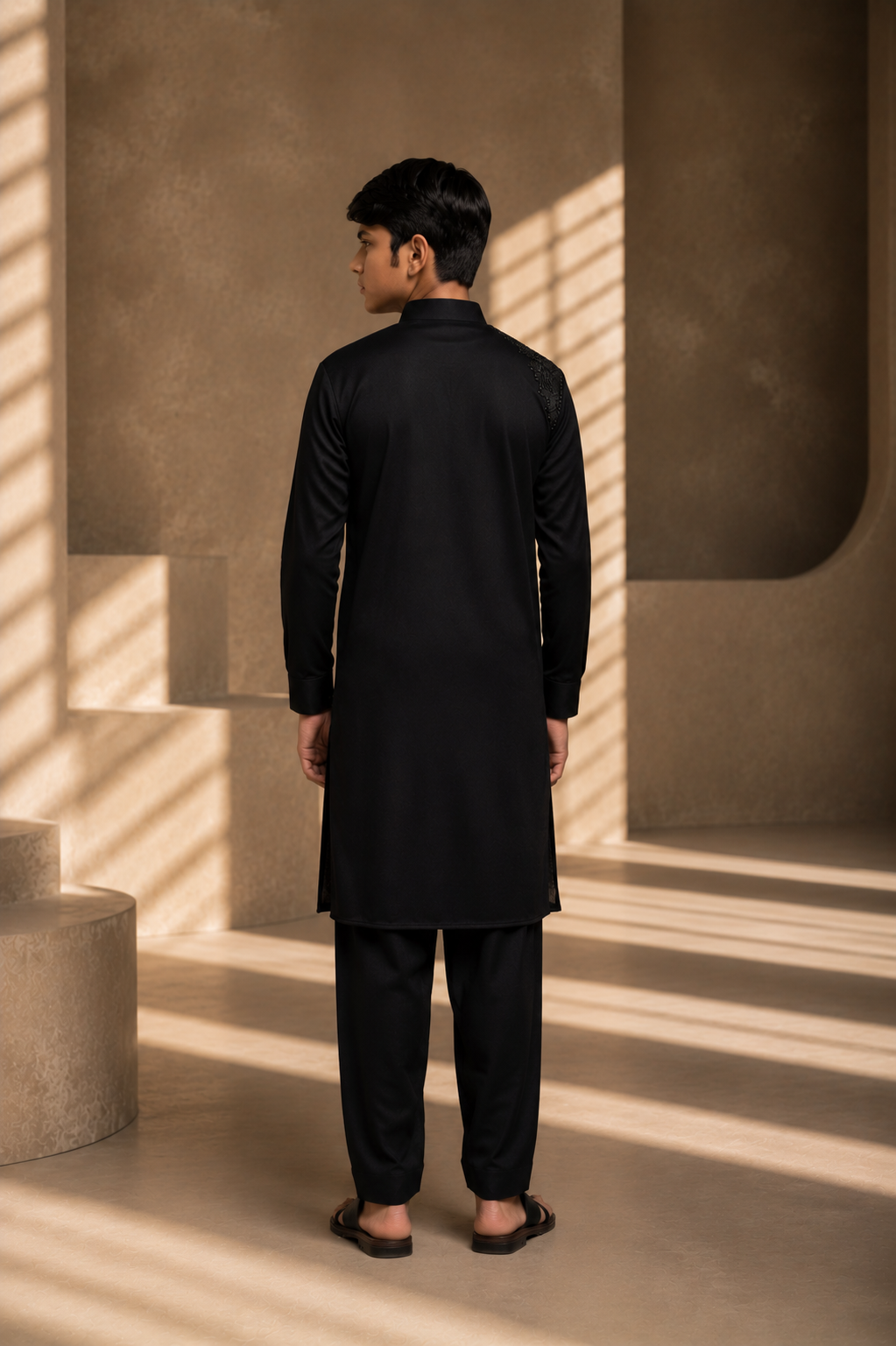 Featuring black knit kurta embellished with antique metal components on one shoulder and zipper detailing paired with aligarhi pants