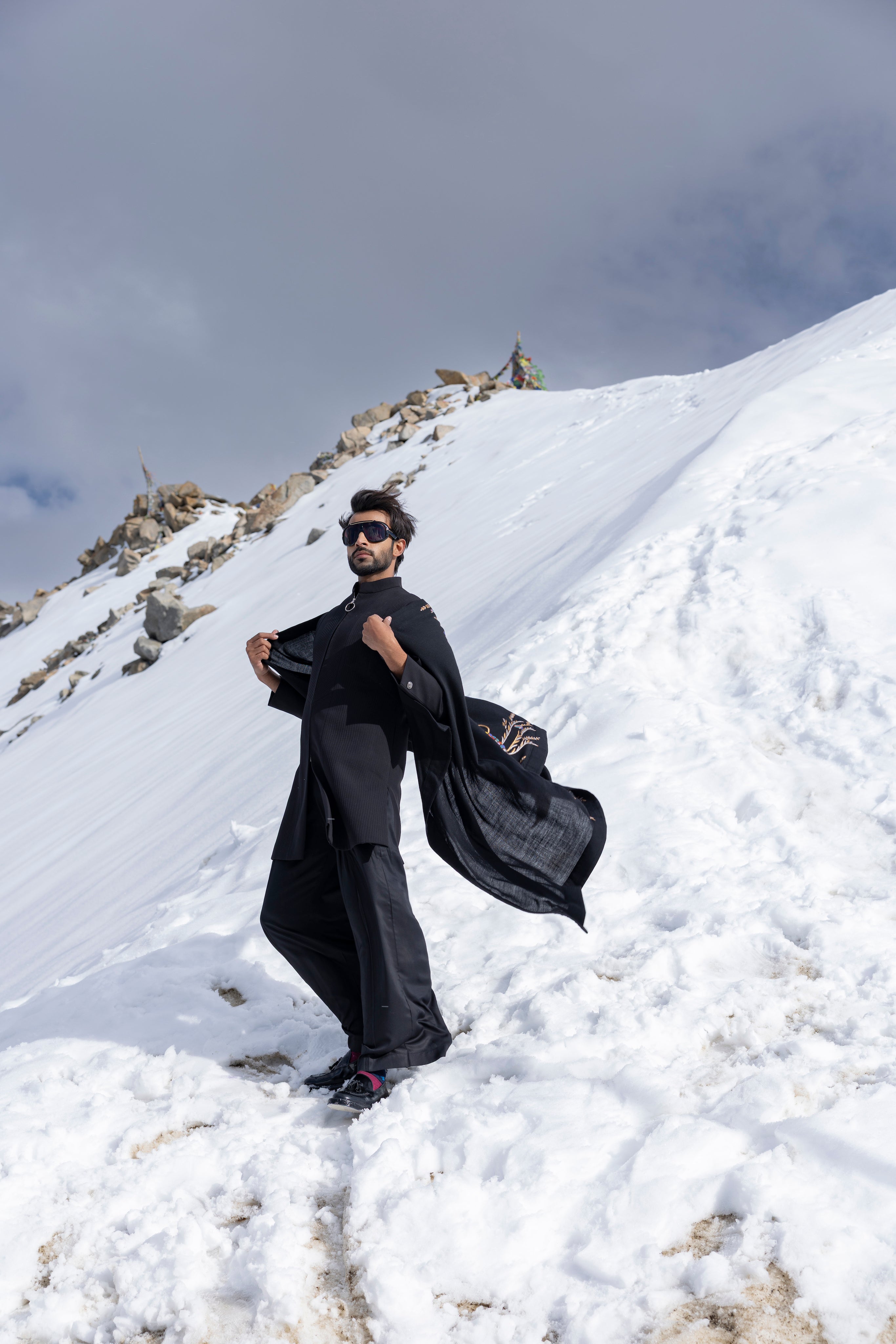 Black front zippered, long textured knit indowestern paired with a black plazo along with an embroidered pashmina stole.