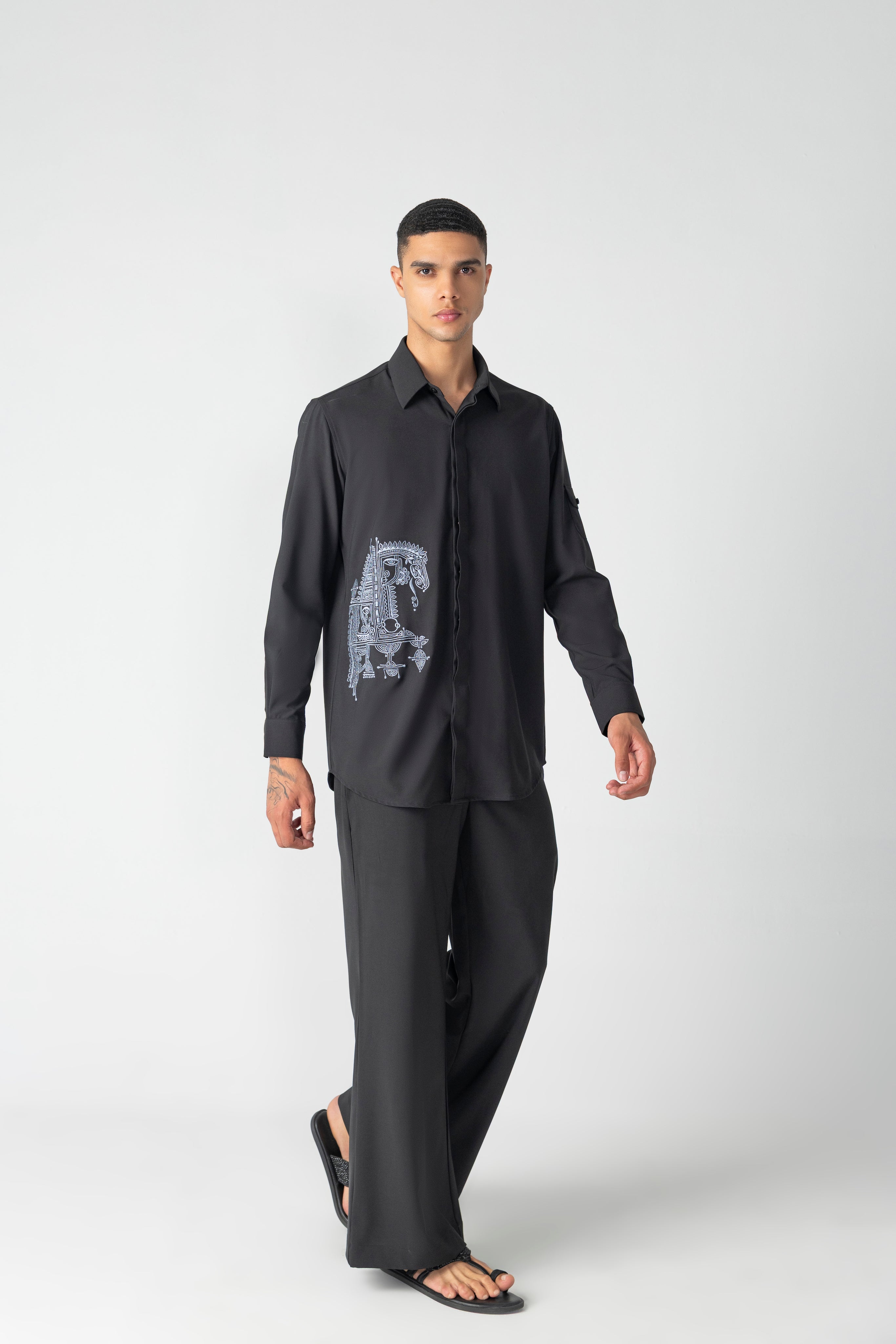 Black crepe shirt with hidden button placket and thread embroidery detailing, paired with a matching plazzo
