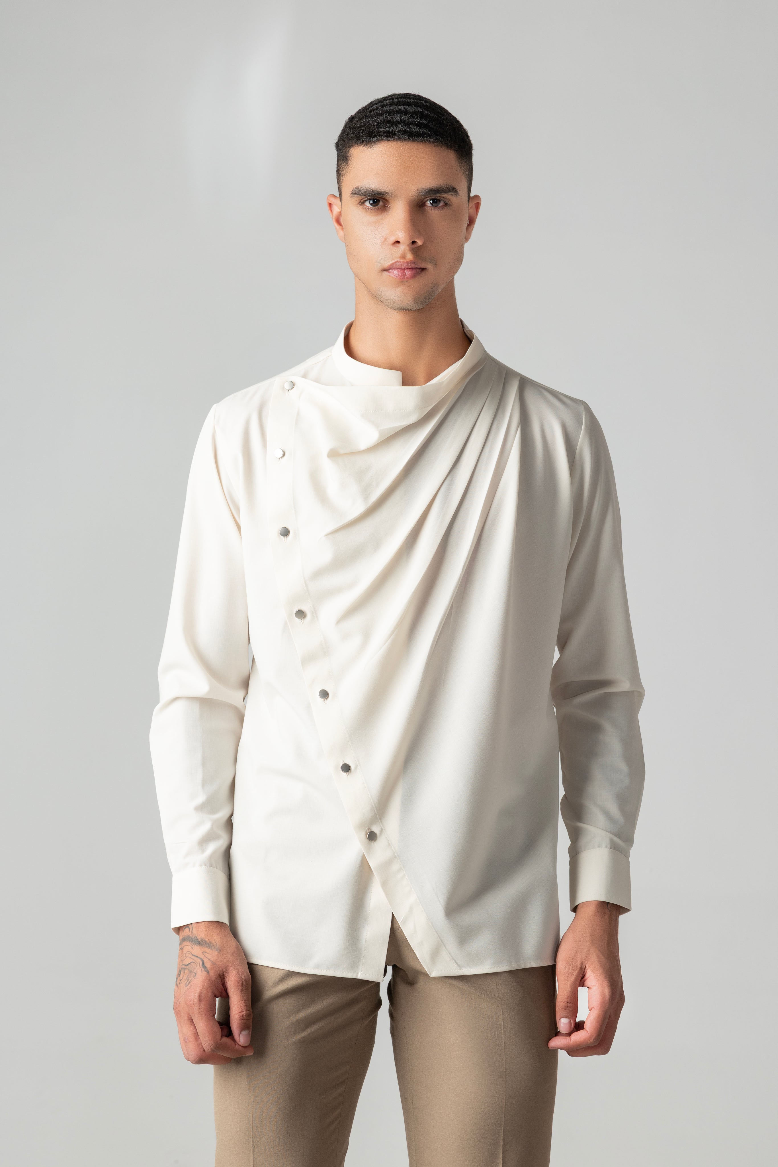 Cream shirt with asymmetrical buttons & drape detailing.