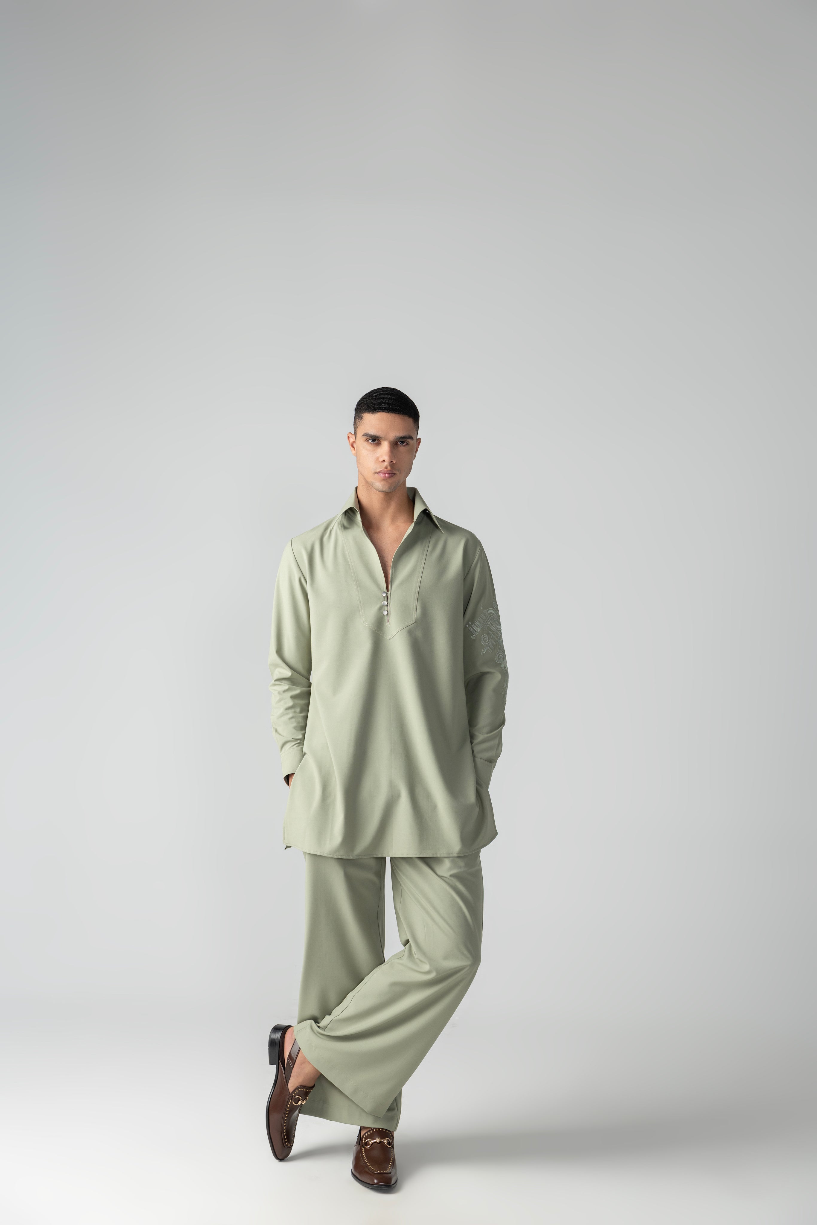 Mint green short crepe kurta with thread embroidery detailing on the sleeve, paired with a matching plazzo