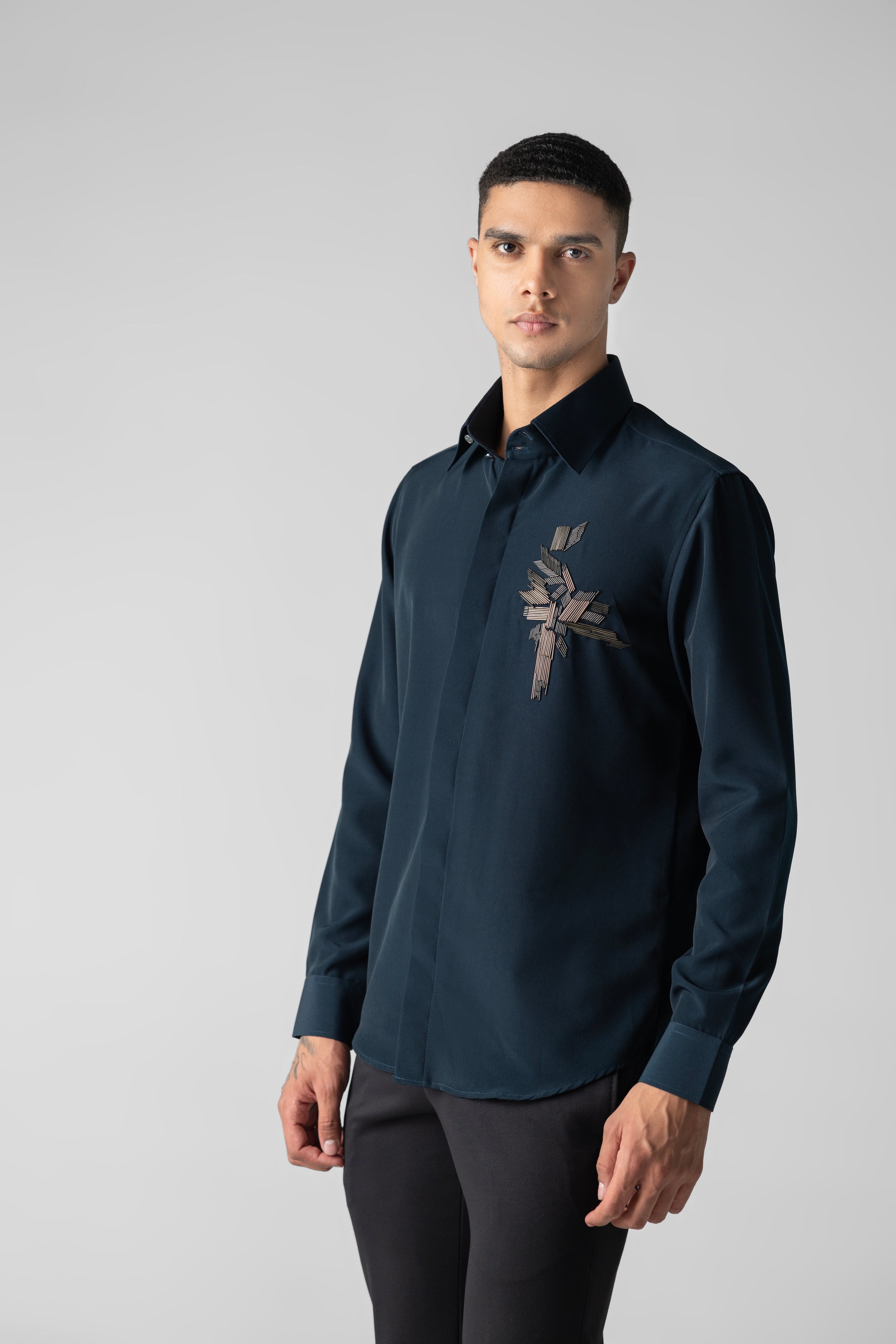 Turquoise shirt with hand-embroidered metal motif